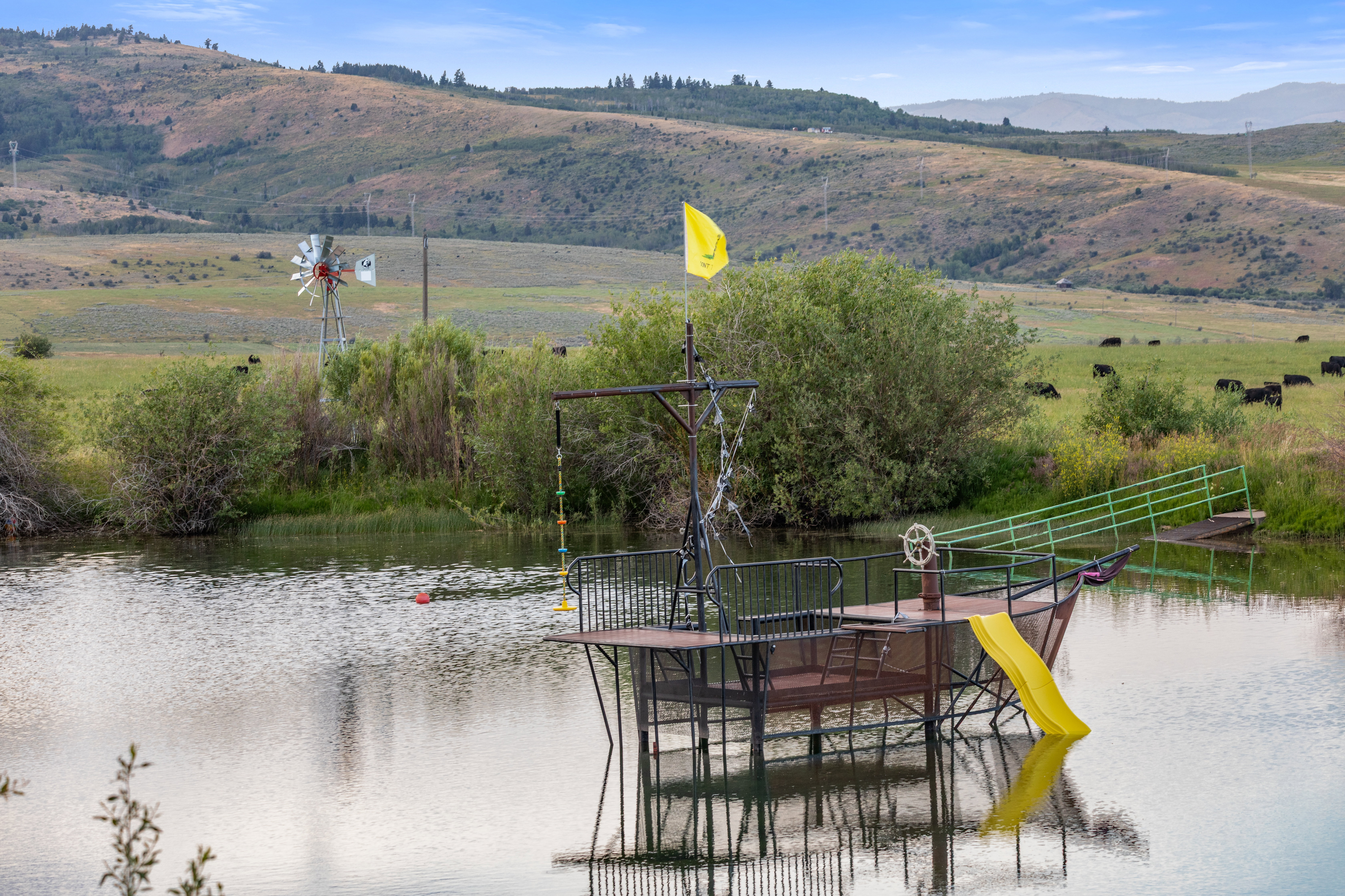Water feature with a custom boat-themed structure, featuring a yellow slide, metal railings, and a small dock