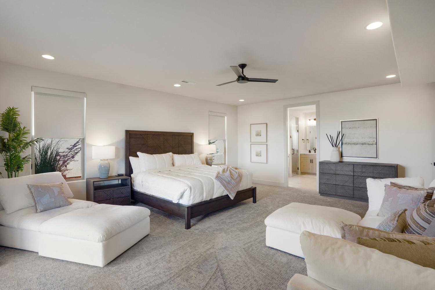 Spacious bedroom featuring plush carpeting, recessed lighting, a modern ceiling fan, and a neutral color palette