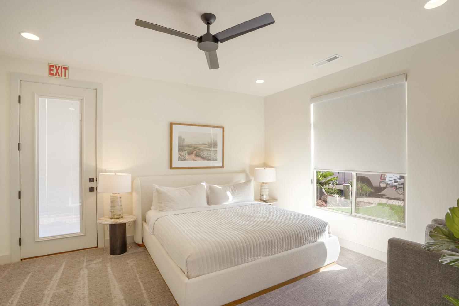 Bright bedroom featuring a large window with a roller shade, recessed lighting, and a modern ceiling fan