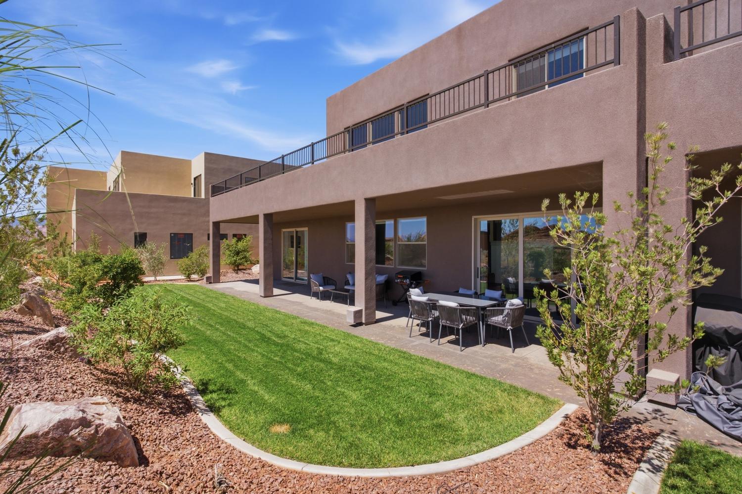 Expansive stucco exterior with an upper-level balcony featuring metal railings