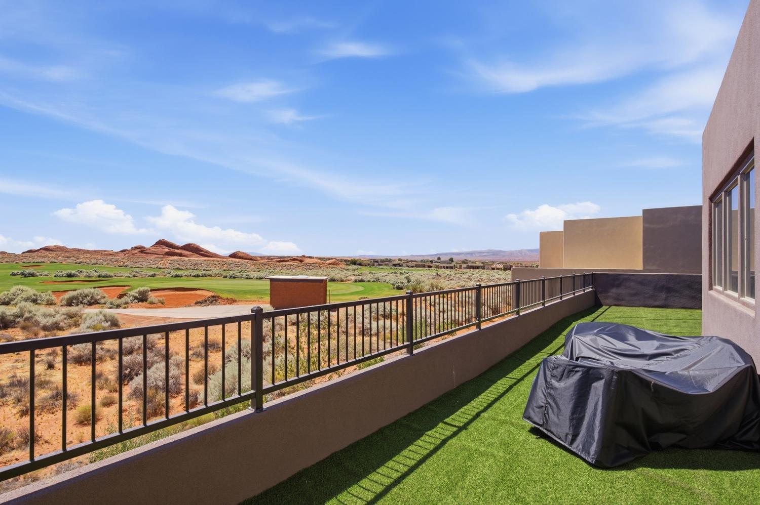 Rooftop patio featuring artificial turf, metal railings, and stucco exterior walls