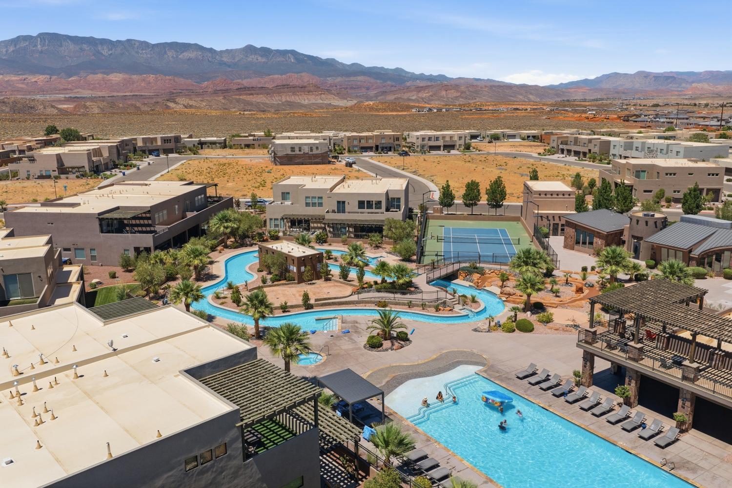 Aerial perspective showcasing a community with a lazy river, swimming pool, and tennis courts