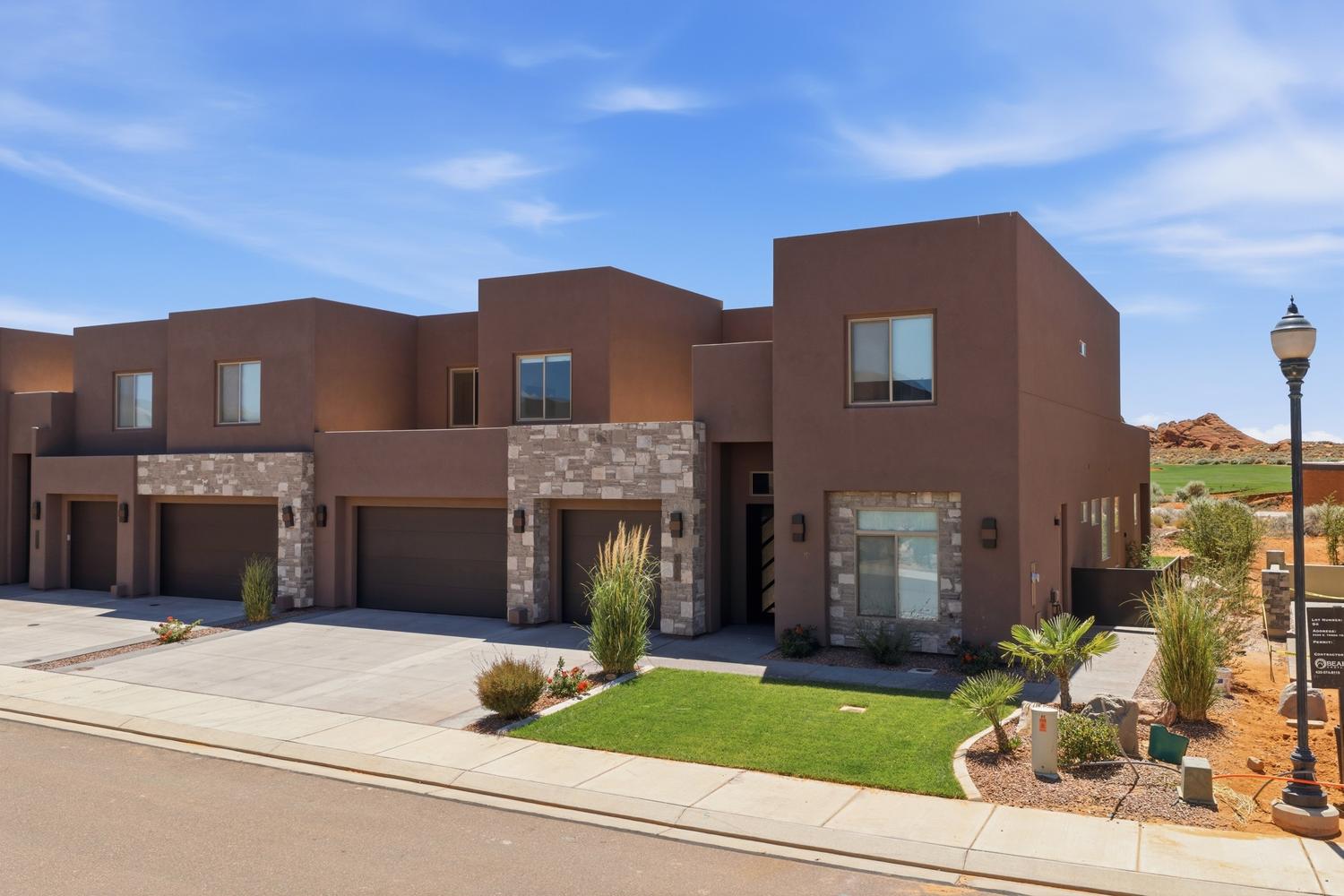 Contemporary townhome exterior featuring a stucco facade and stone accents