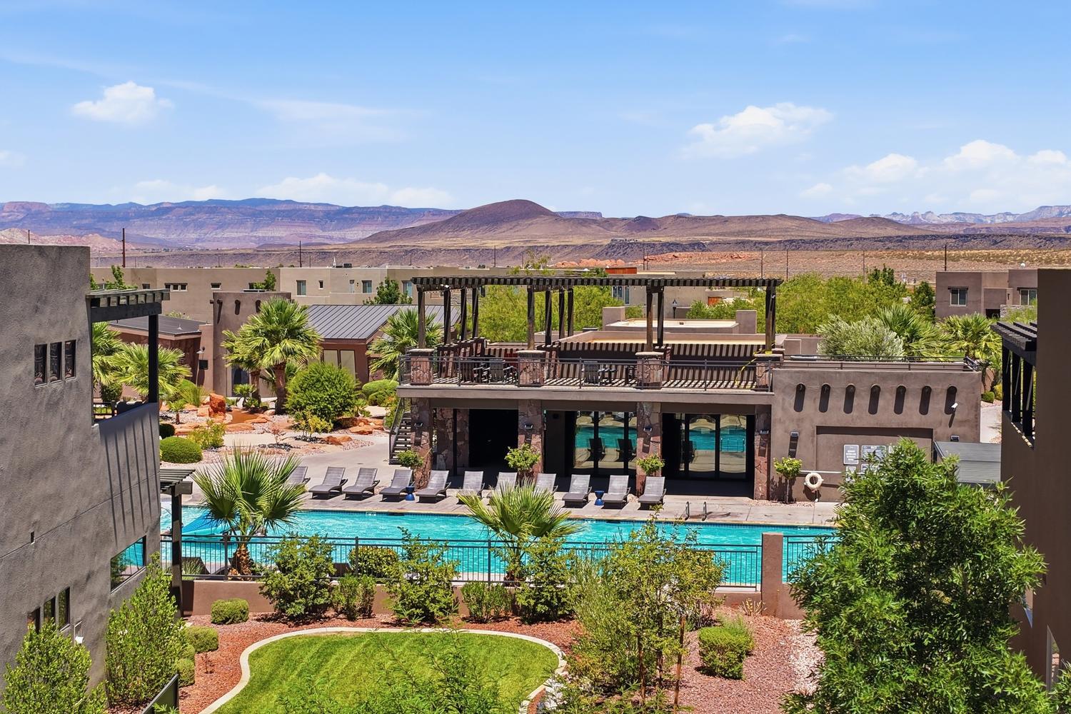 Outdoor pool and lounge area featuring a pergola-covered upper deck, a ground-level patio with sun loungers, perimeter fencing, and surrounding landscaping