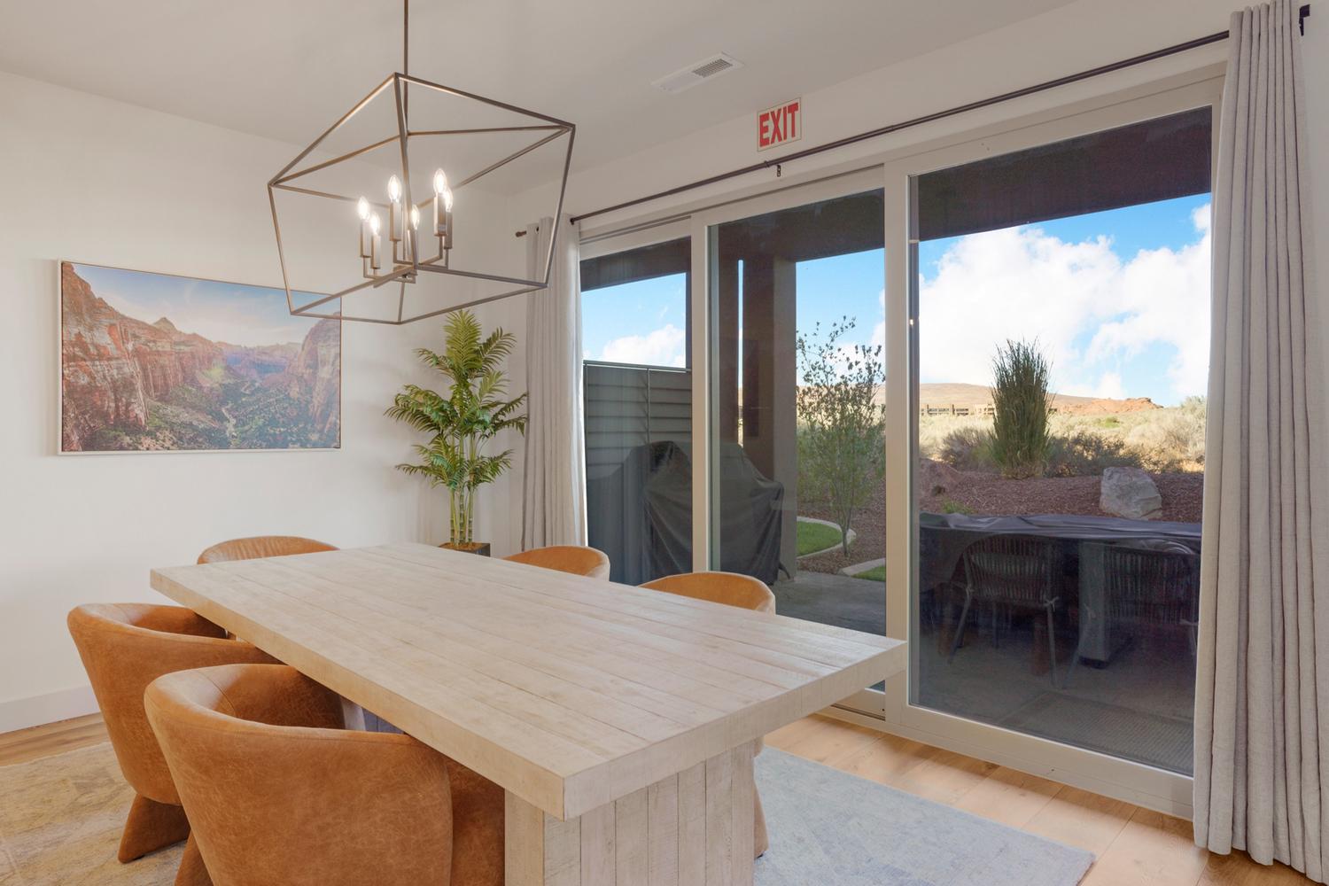 Bright interior space featuring a large sliding glass door, a contemporary geometric chandelier, and light wood-finish flooring