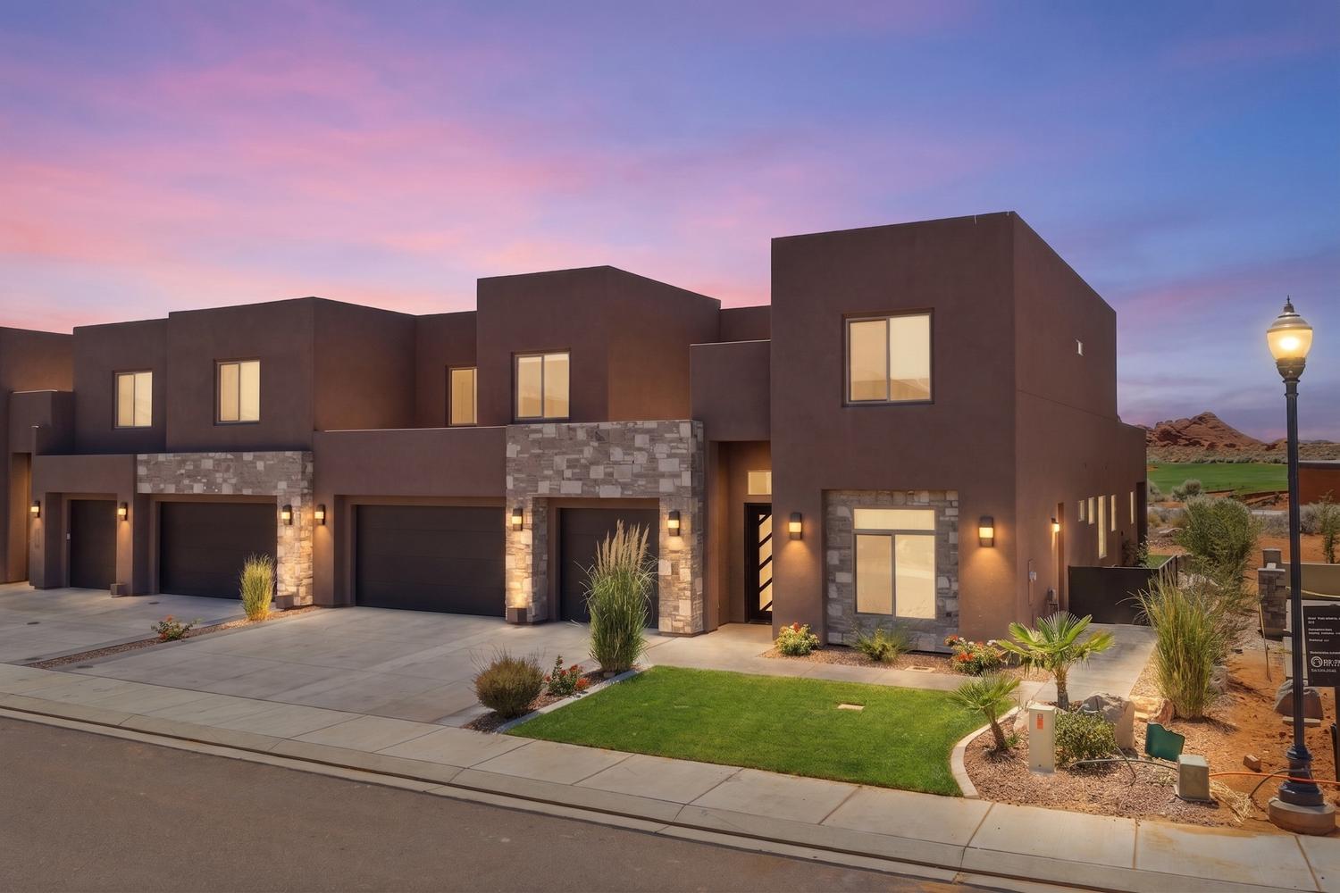 Contemporary townhome exterior featuring stucco and natural stone accents