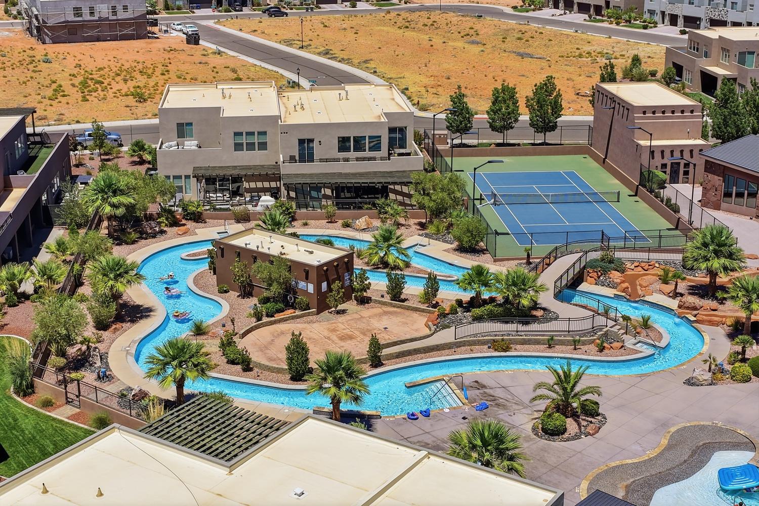 Expansive water park featuring a lazy river, surrounded by palm trees and desert landscaping