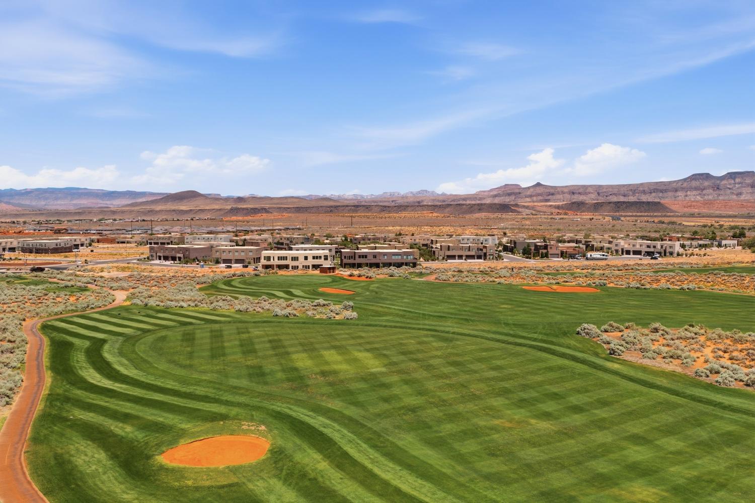 Expansive golf course landscaping featuring striped green fairways and a sand trap