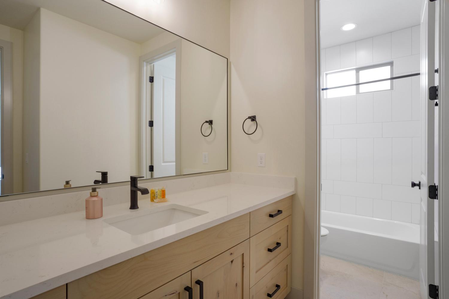 Bathroom featuring a light wood-finish vanity with a white countertop and integrated rectangular sink