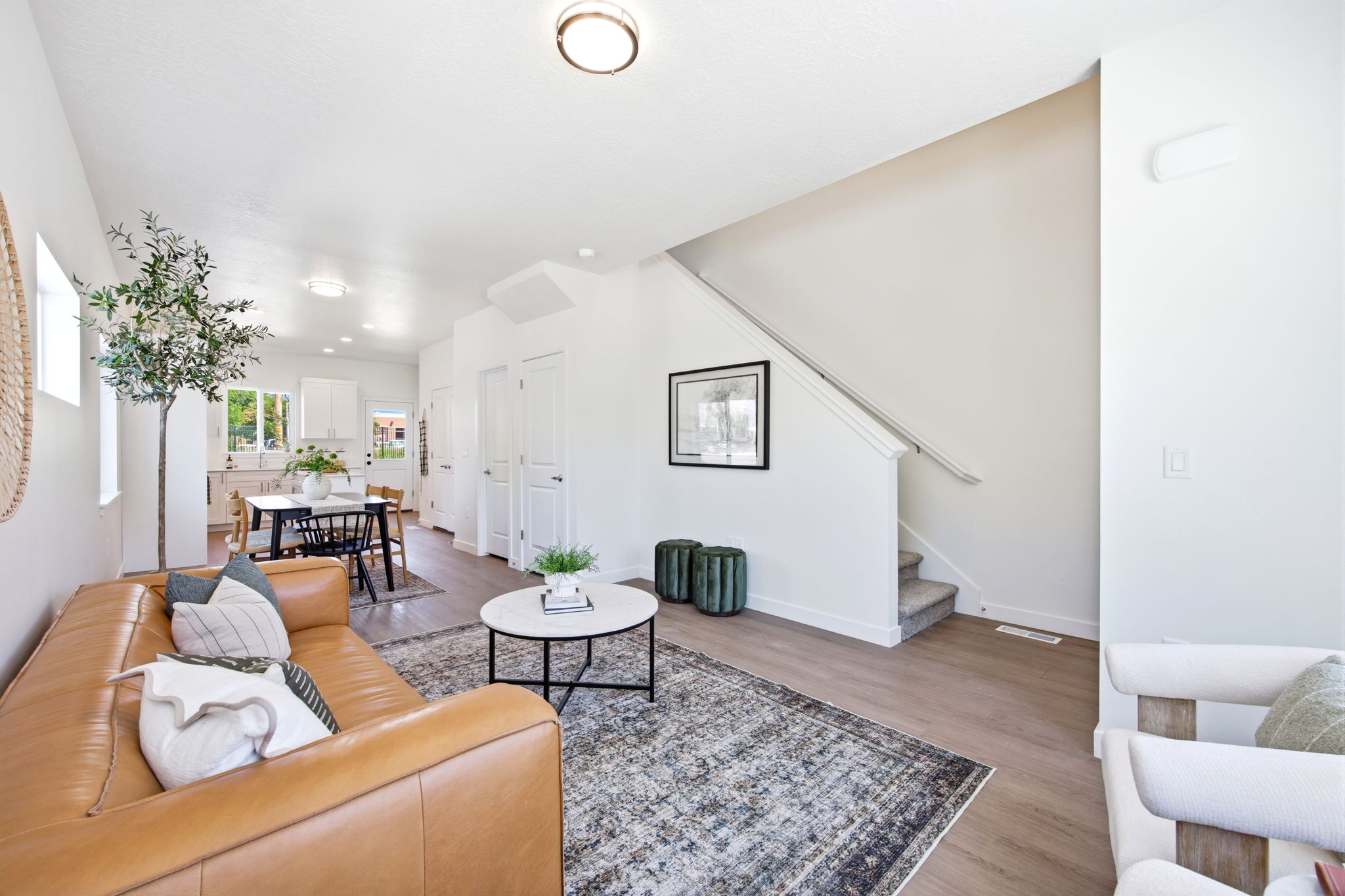 Open-concept living space featuring wood-finish flooring, recessed lighting, and a neutral color palette