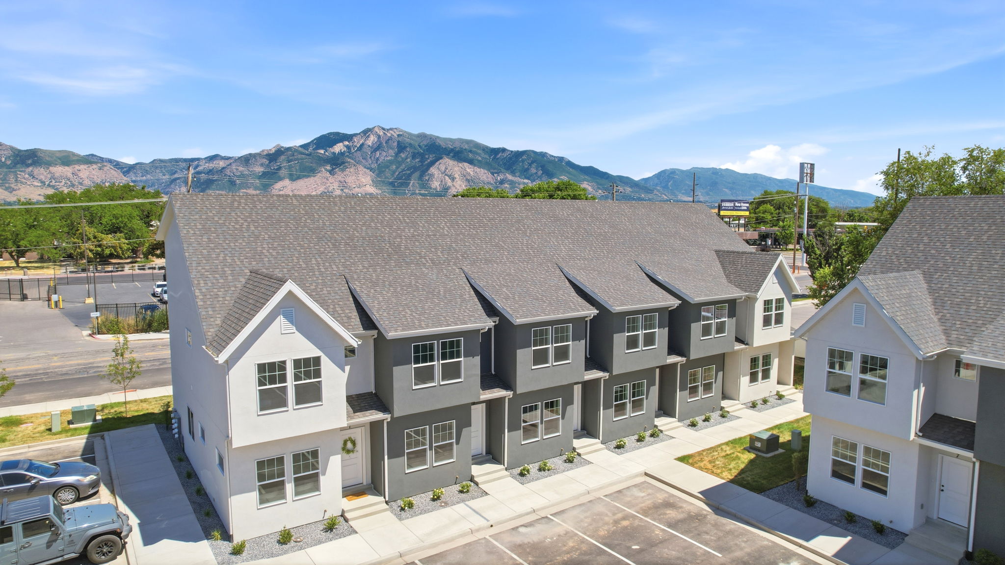 Contemporary townhome exteriors featuring gabled roofs and a mix of light and dark gray siding