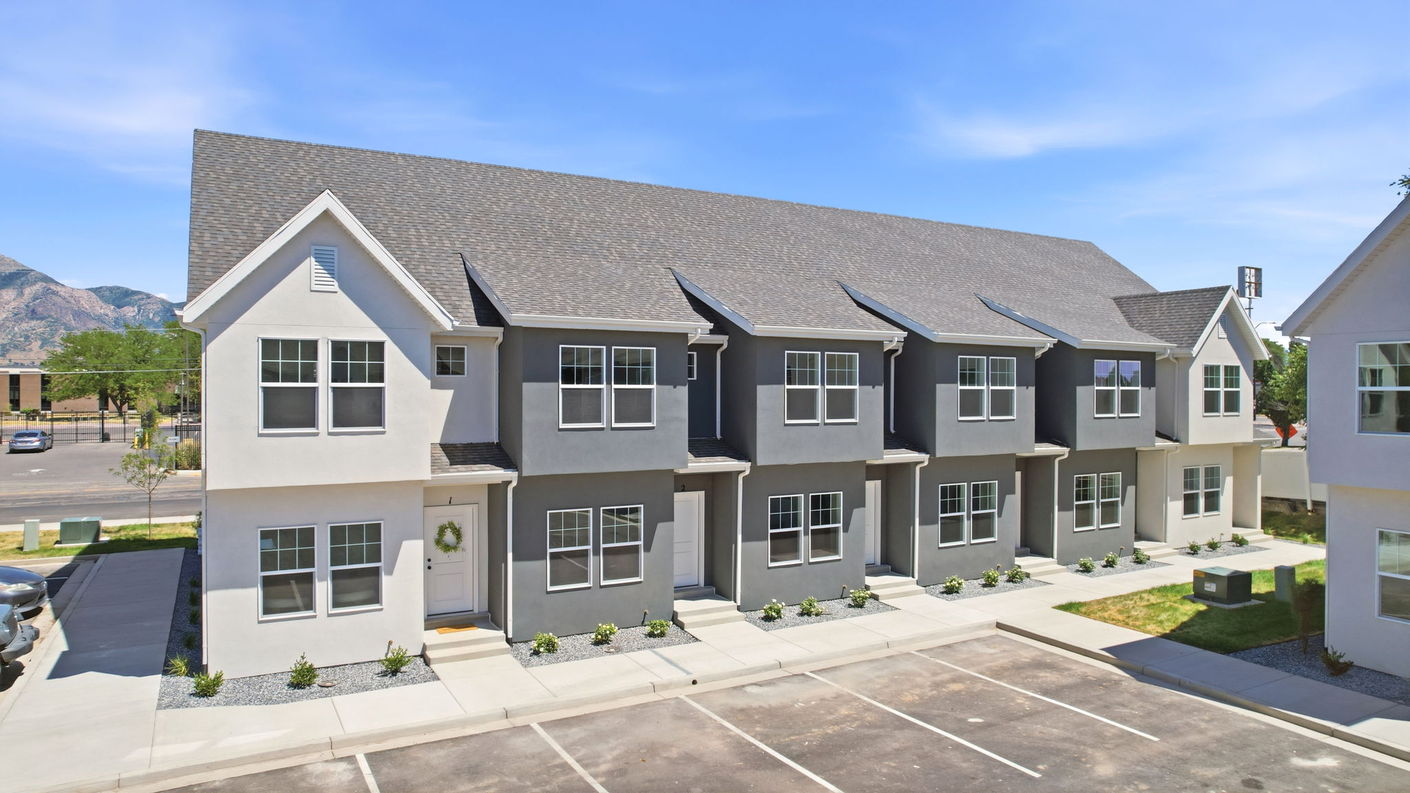 Contemporary townhome-style units with a gray and white facade