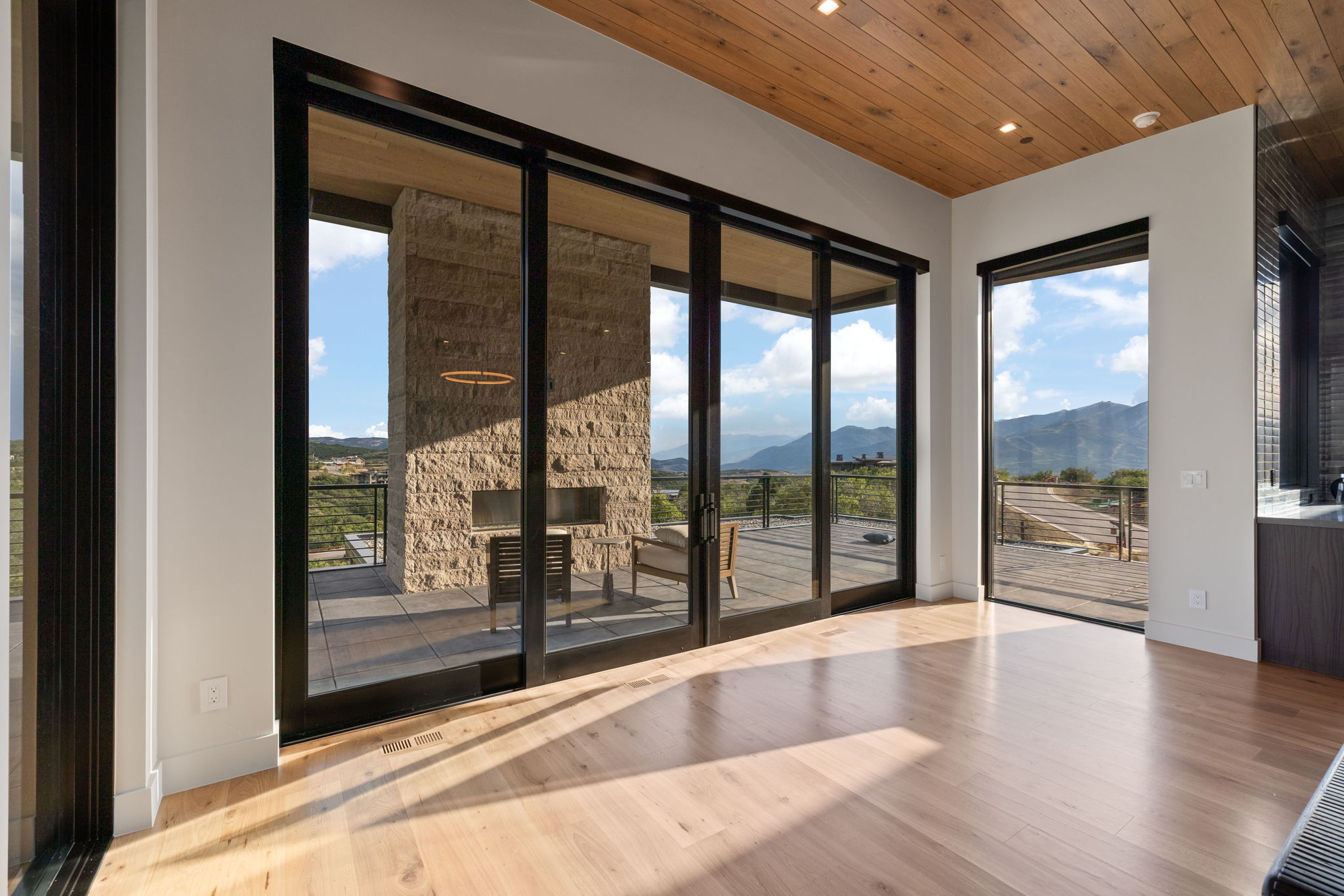 Hardwood flooring extends through this room, featuring a wood-panel ceiling and recessed lighting