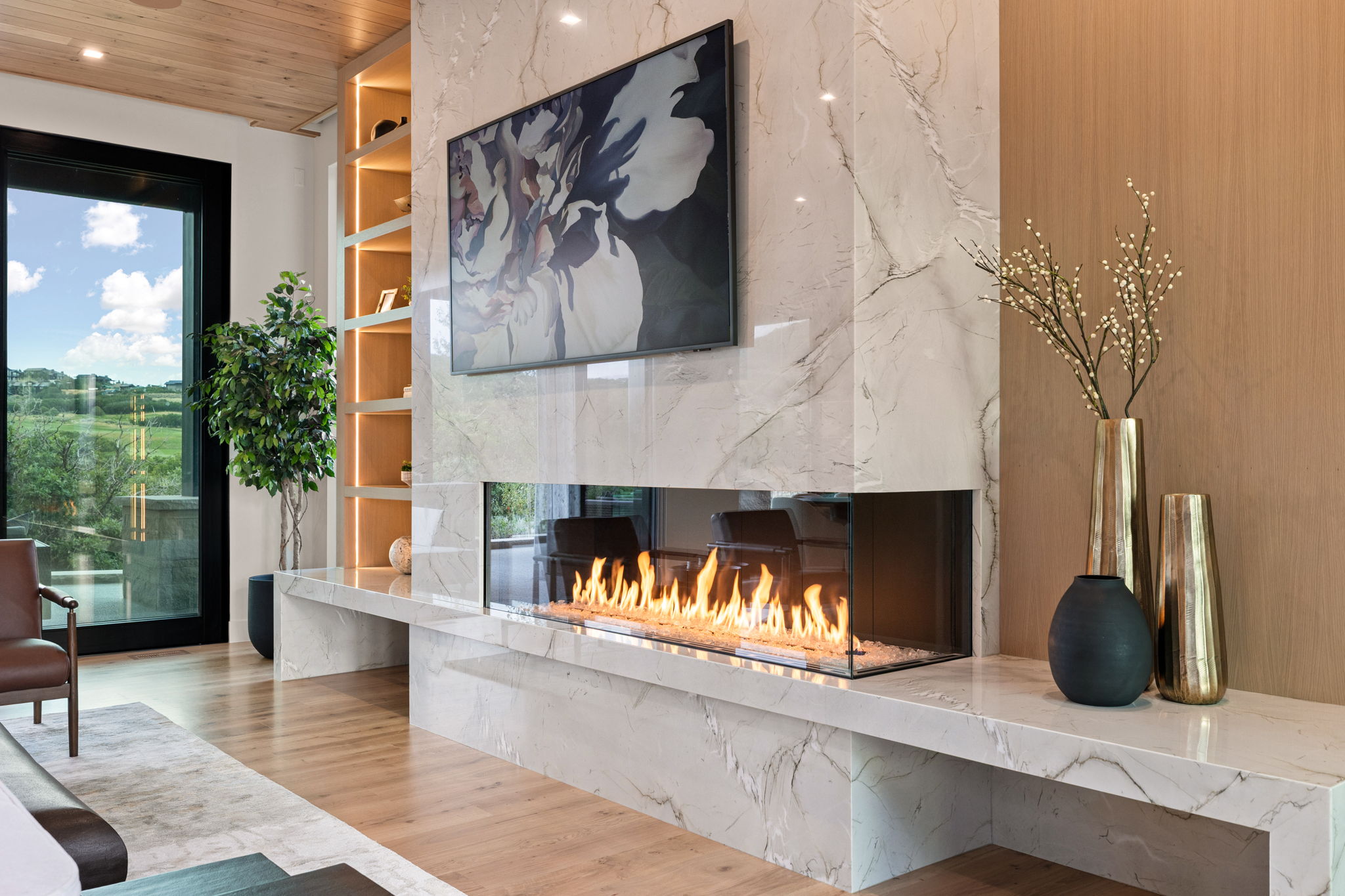 Contemporary fireplace feature wall with a linear gas fireplace, marble-finish surround, and integrated shelving