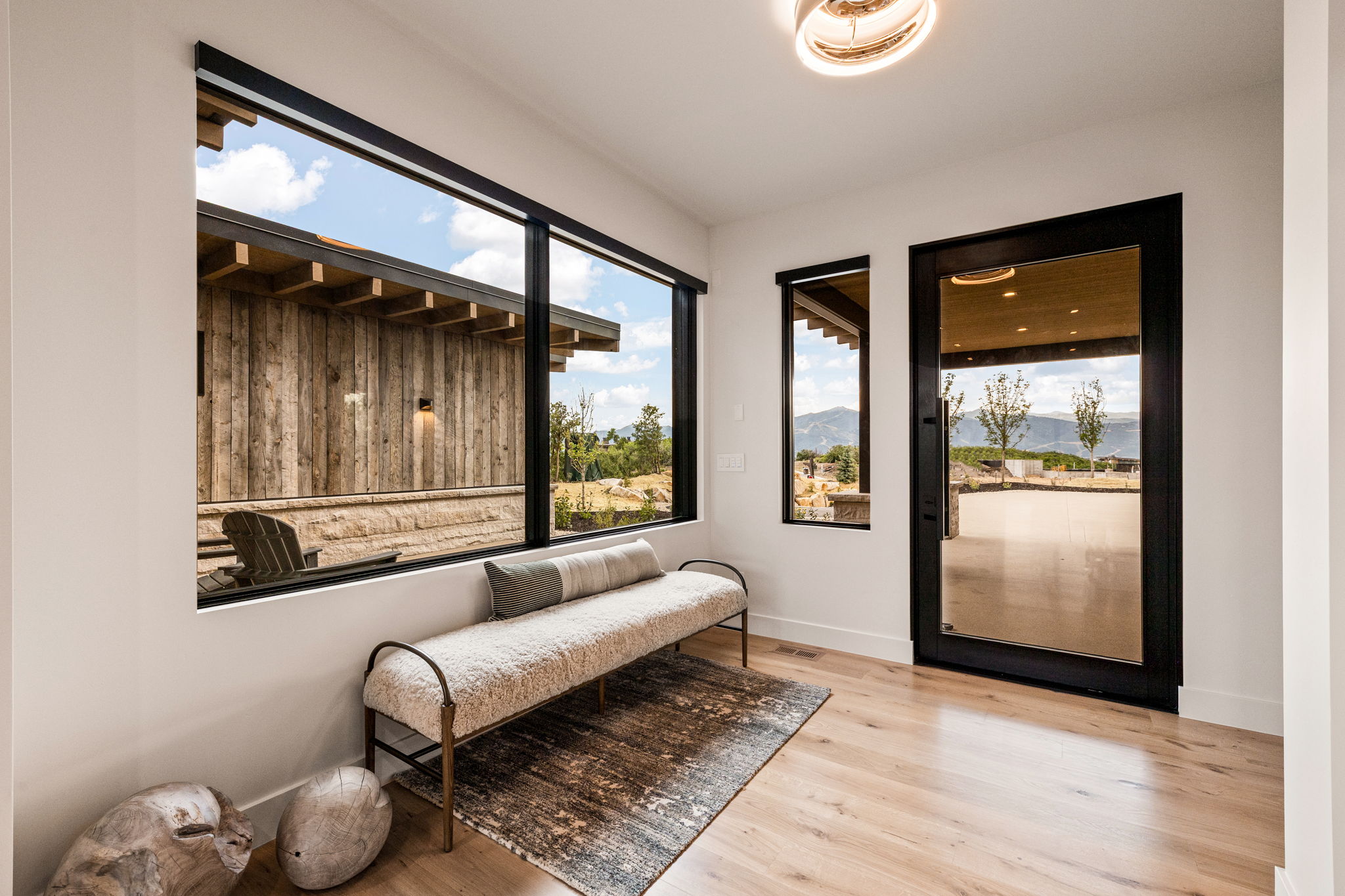 Modern entryway with wood-finish flooring, a full-lite glass entry door, and expansive windows