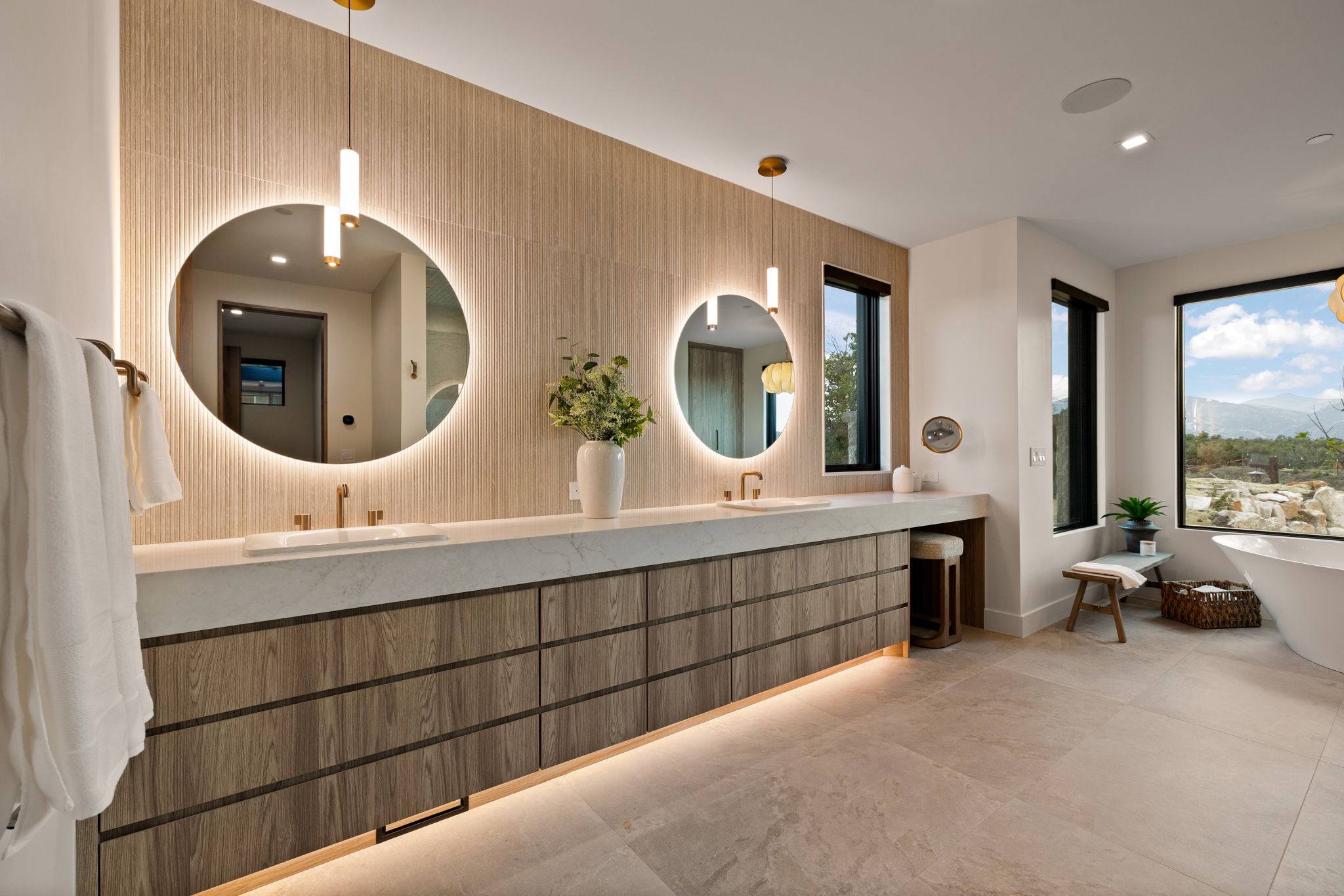 Double vanity featuring wood-finish cabinetry, a light-toned countertop, and integrated undermount sinks