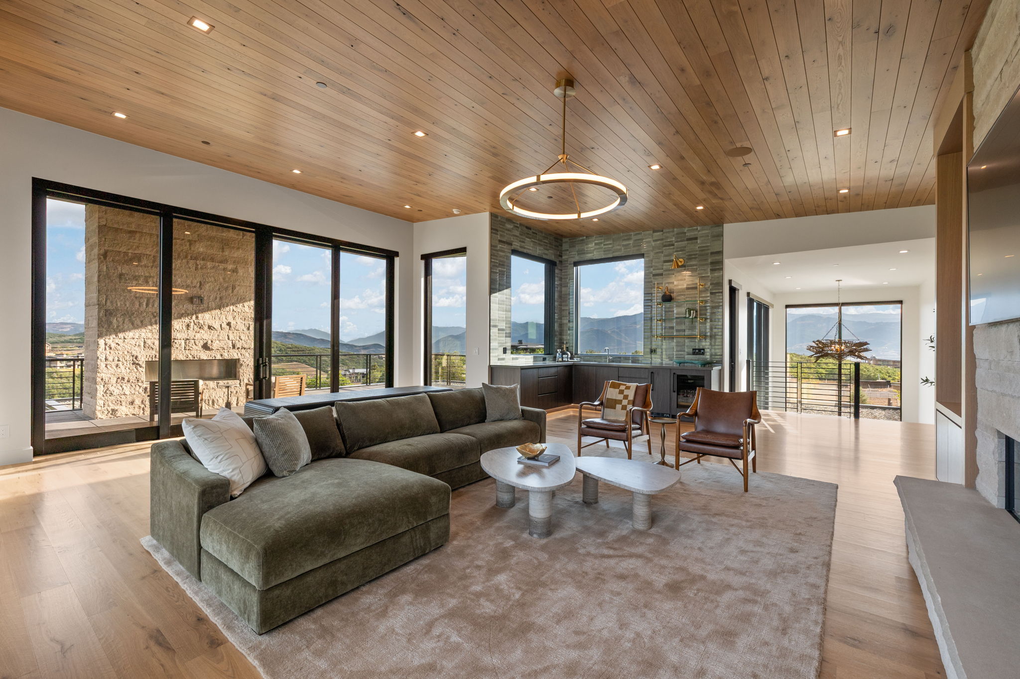 Expansive living area featuring wood-finish flooring and a wood-paneled ceiling with recessed lighting