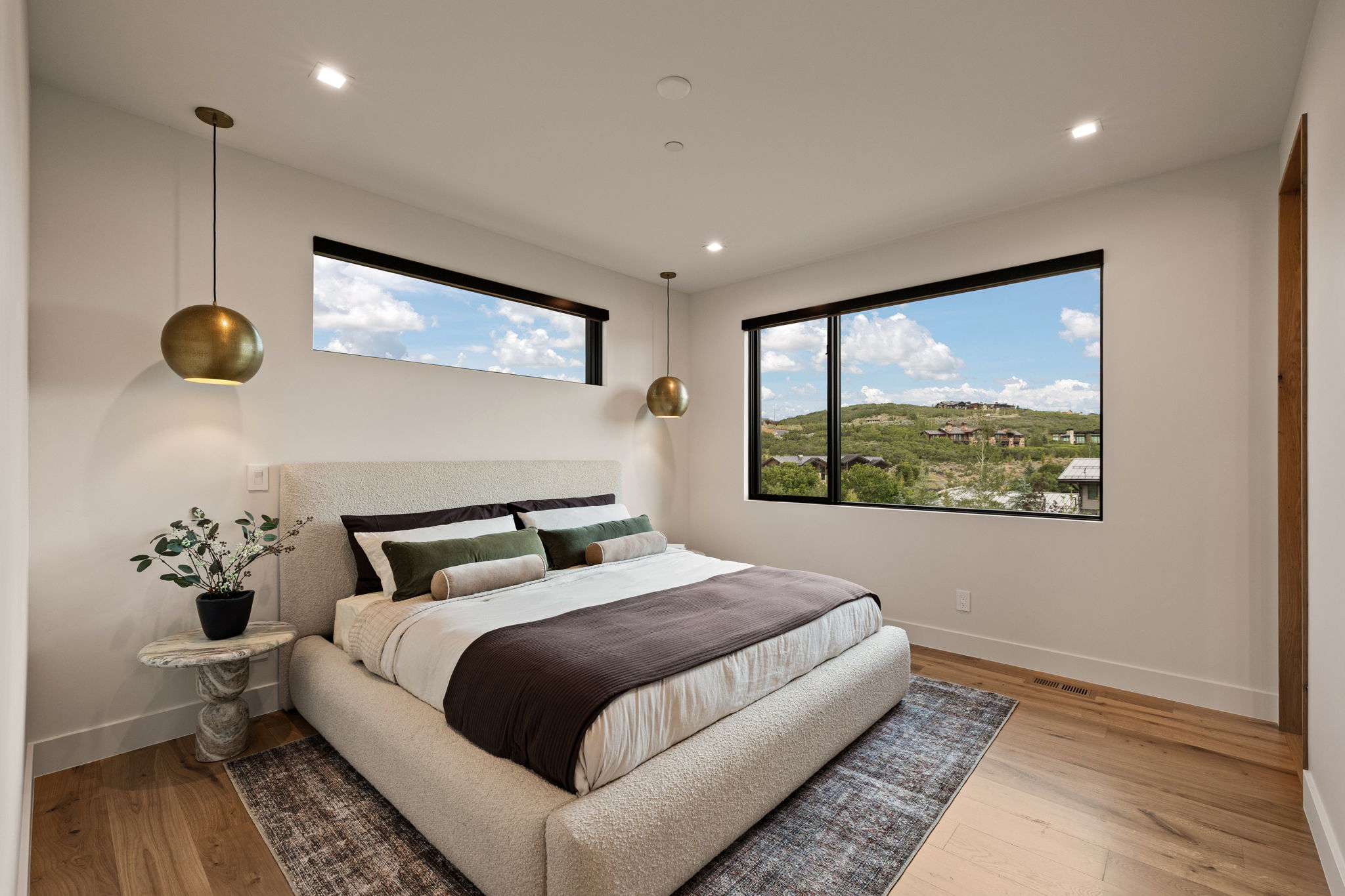 Bedroom featuring hardwood flooring, recessed lighting, and a large picture window