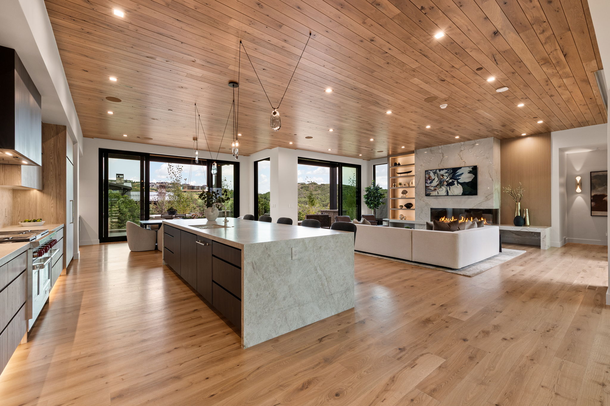Open-concept living area featuring wood-finish flooring and a wood-paneled ceiling