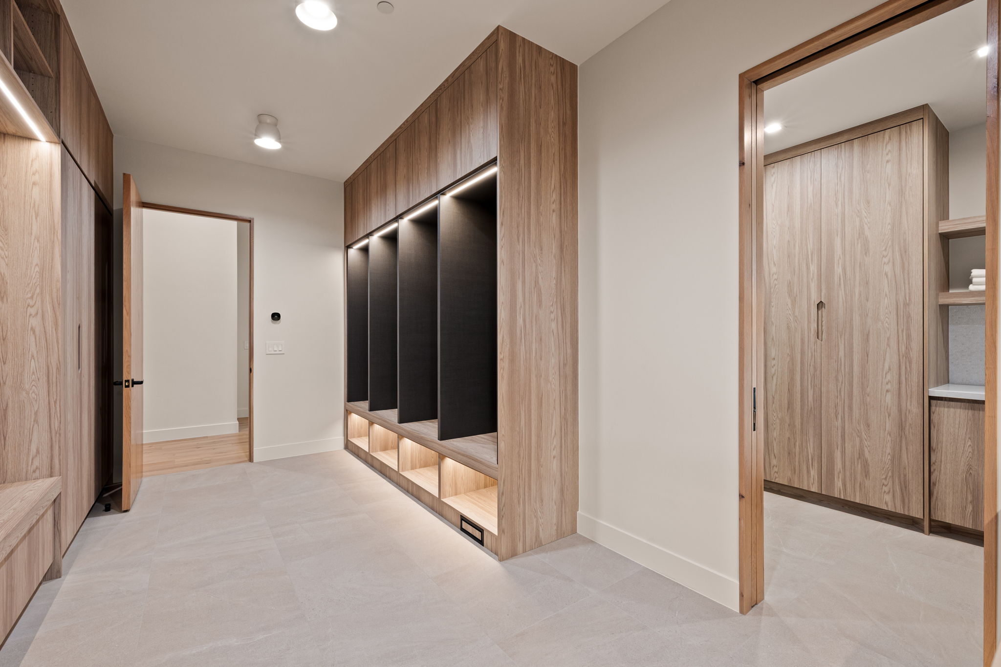 Built-in wood-finish cabinetry featuring open cubbies with integrated lighting, wood-finish flooring, and recessed ceiling lights