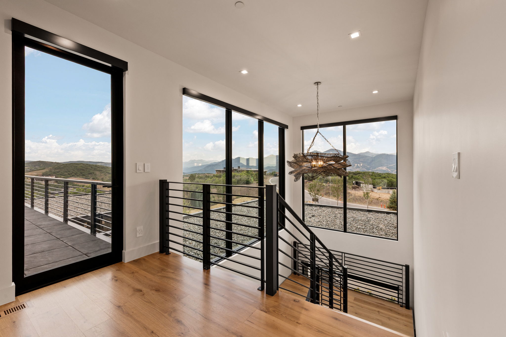 Upper-level landing featuring wood-finish flooring and a contemporary chandelier