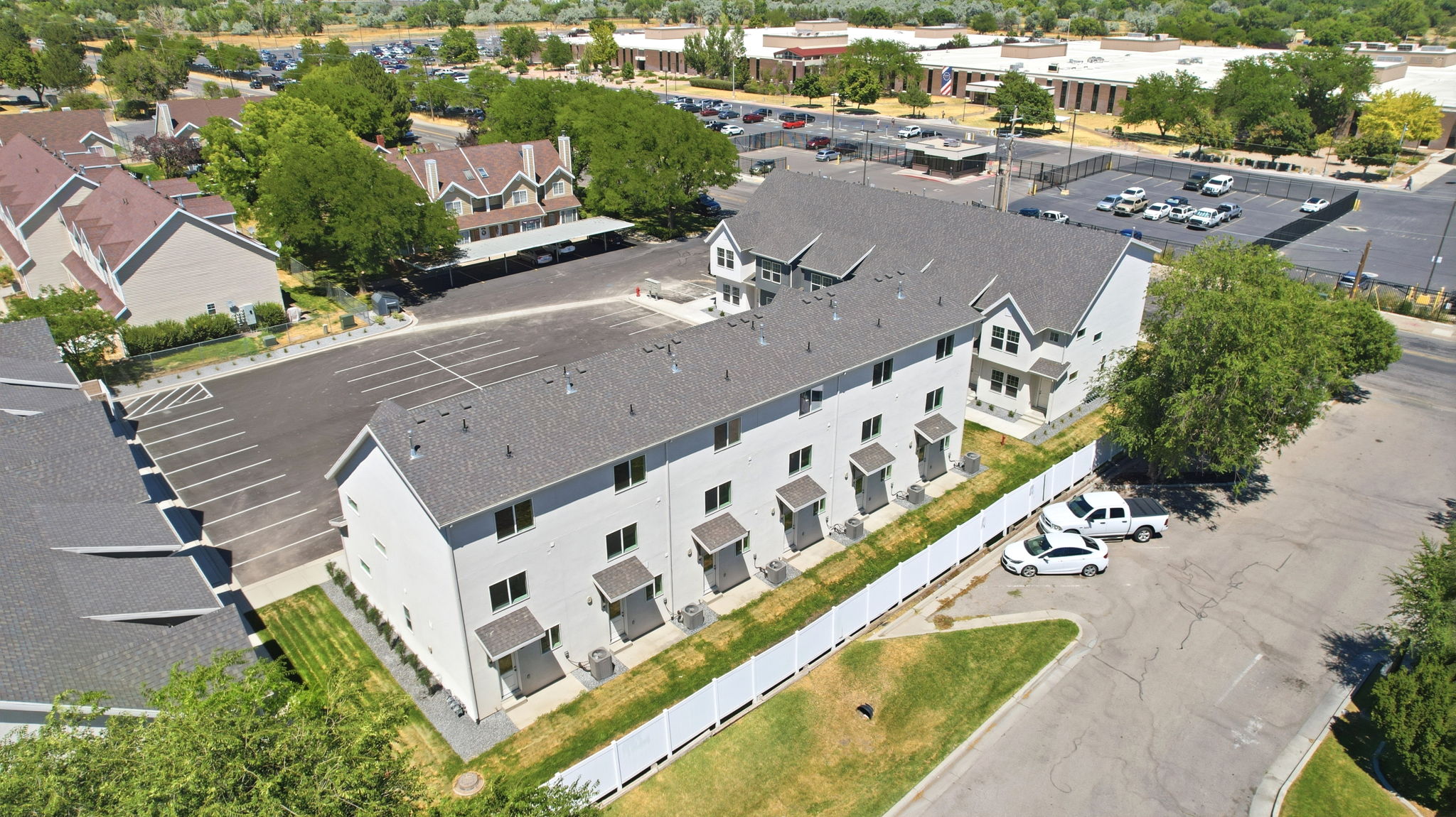 Multi-unit residential structure featuring a gray shingle roof and light-colored siding