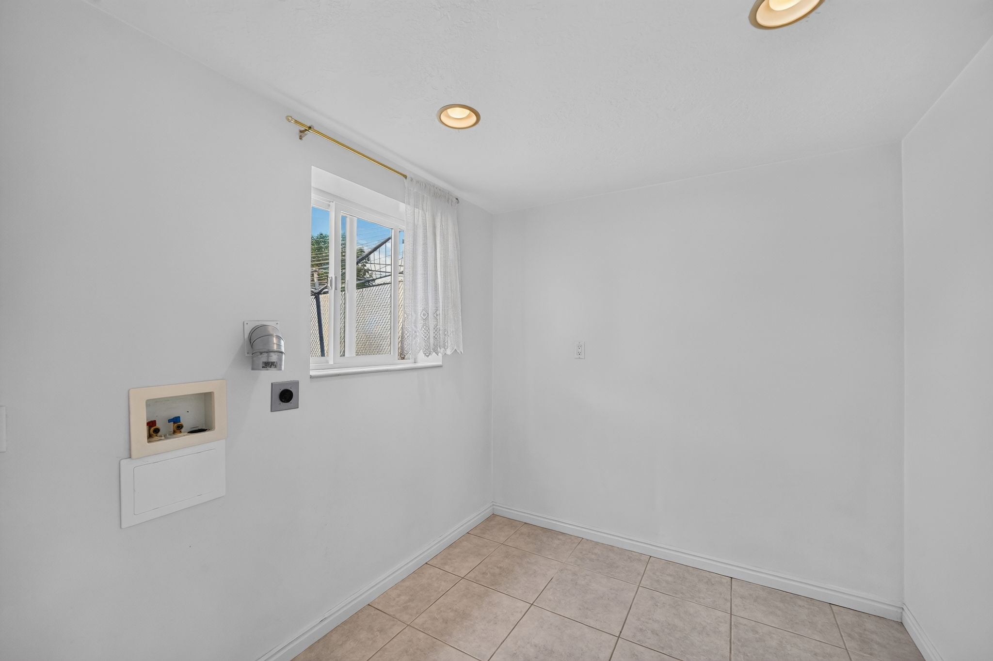 Utility area featuring tiled flooring, a window with natural light, recessed ceiling lighting, and hookups for laundry appliances