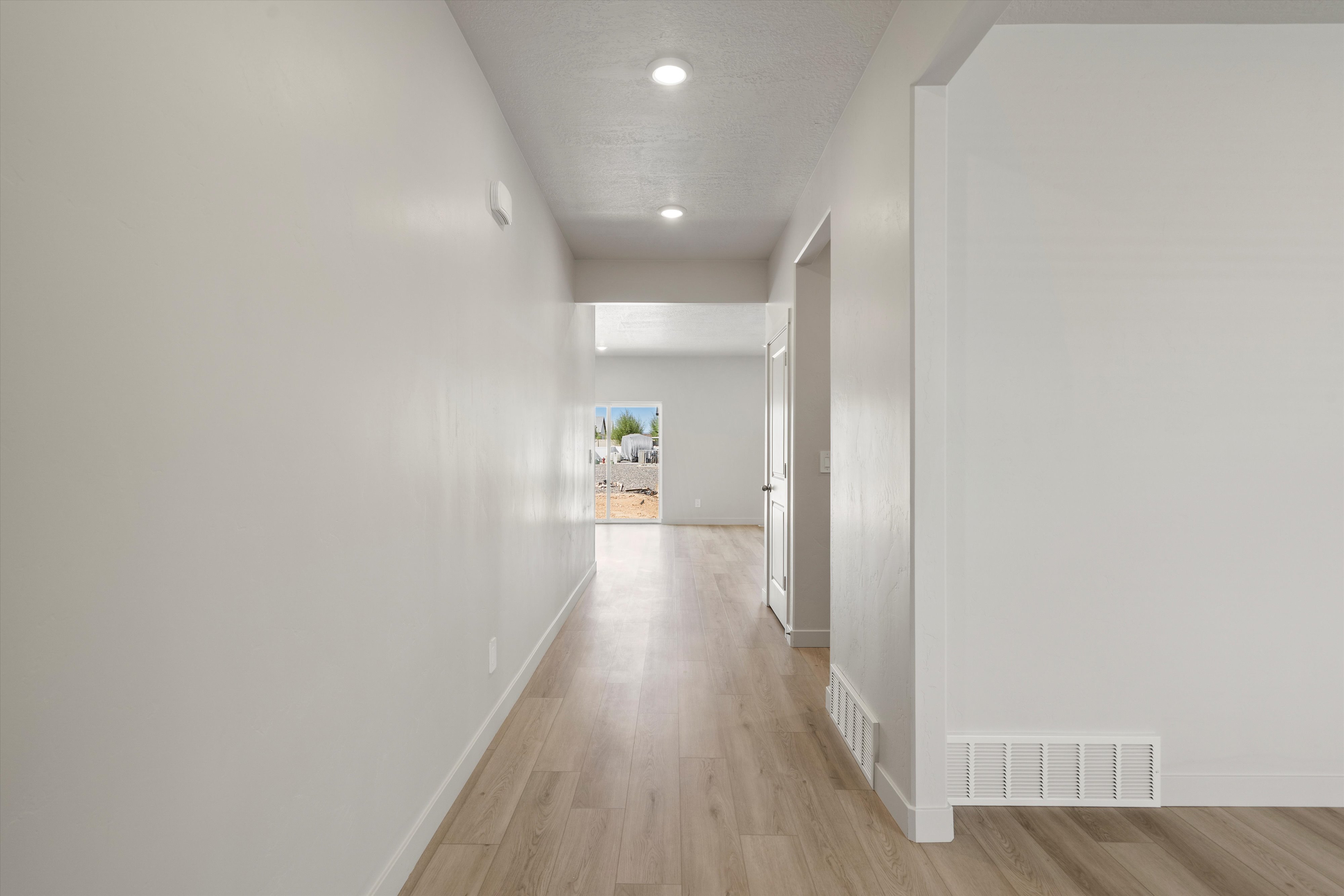 Hallway featuring wood-finish flooring, recessed lighting, white trim, and light-toned walls