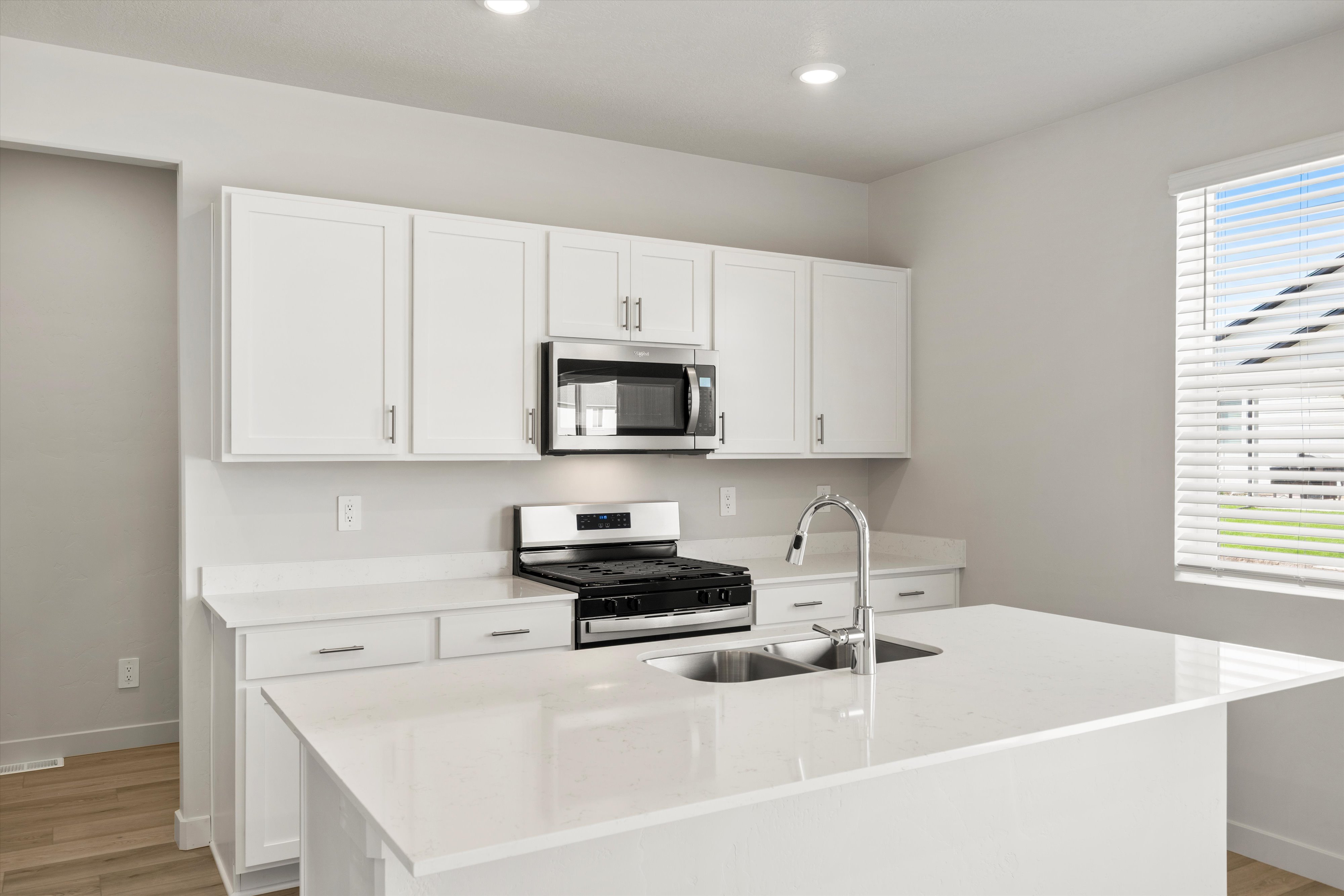 Modern kitchen with an island featuring a dual basin sink and chrome faucet