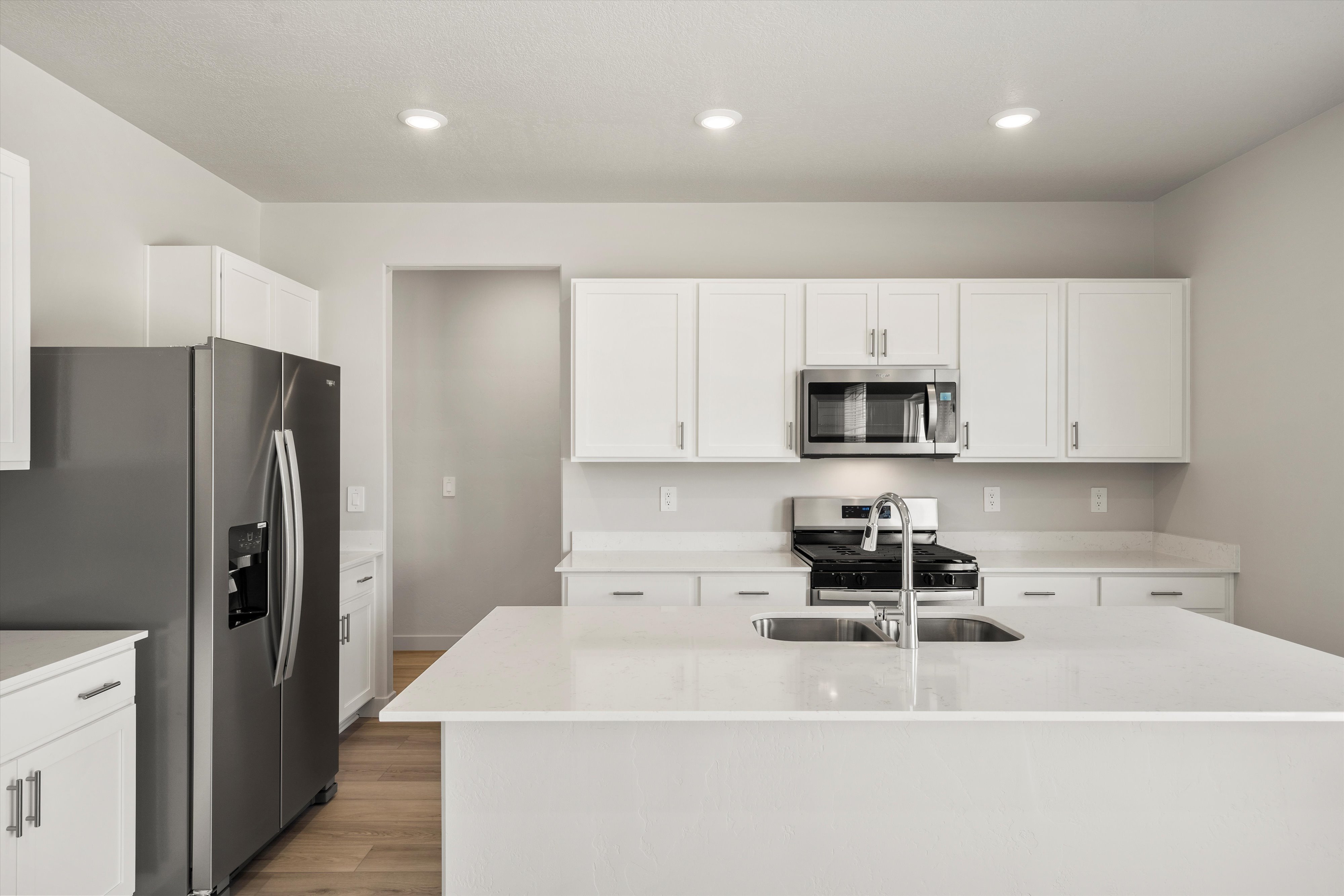Modern kitchen featuring a large island with an integrated double basin sink and chrome faucet