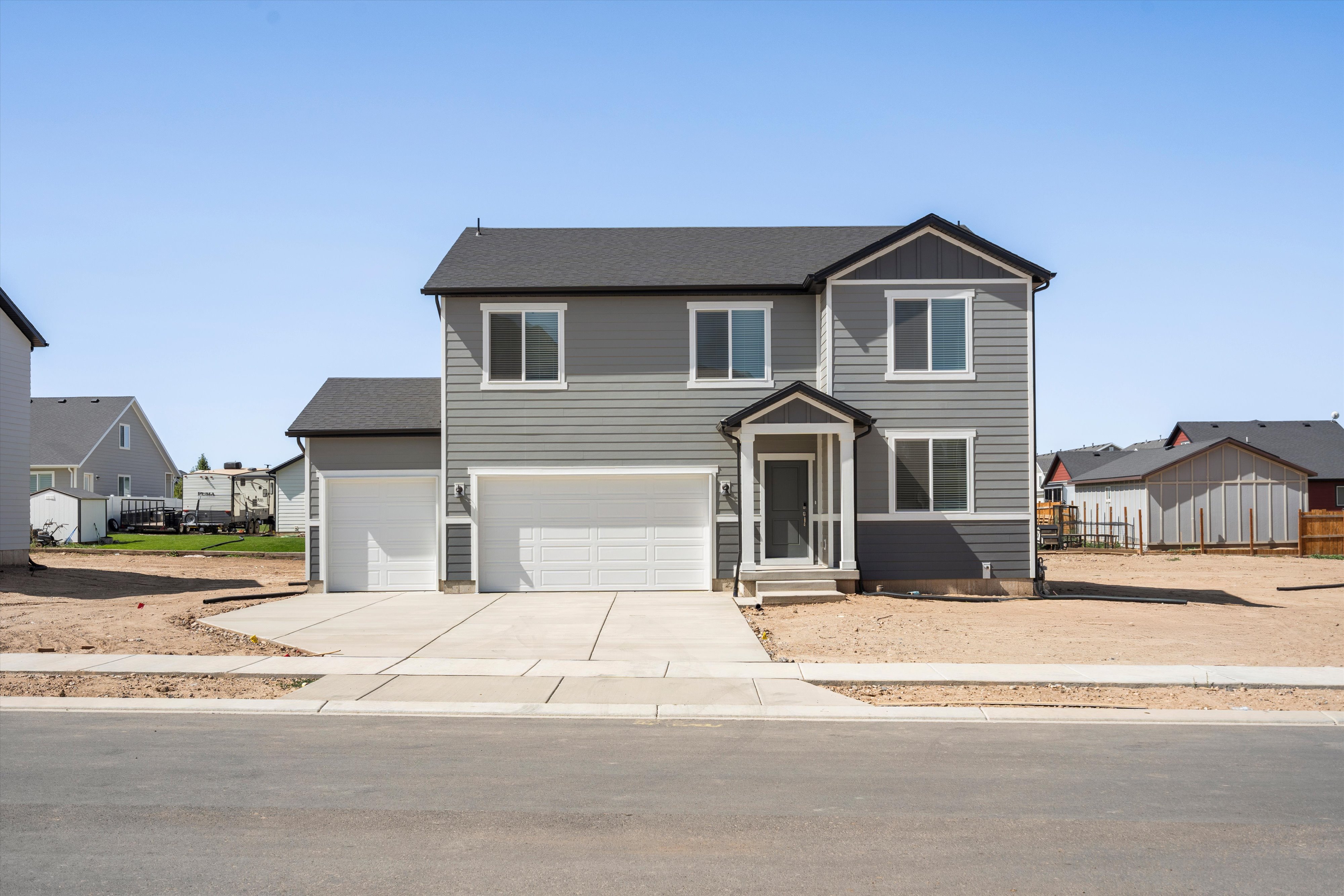 Contemporary two-story residence featuring gray horizontal siding and dark trim accents