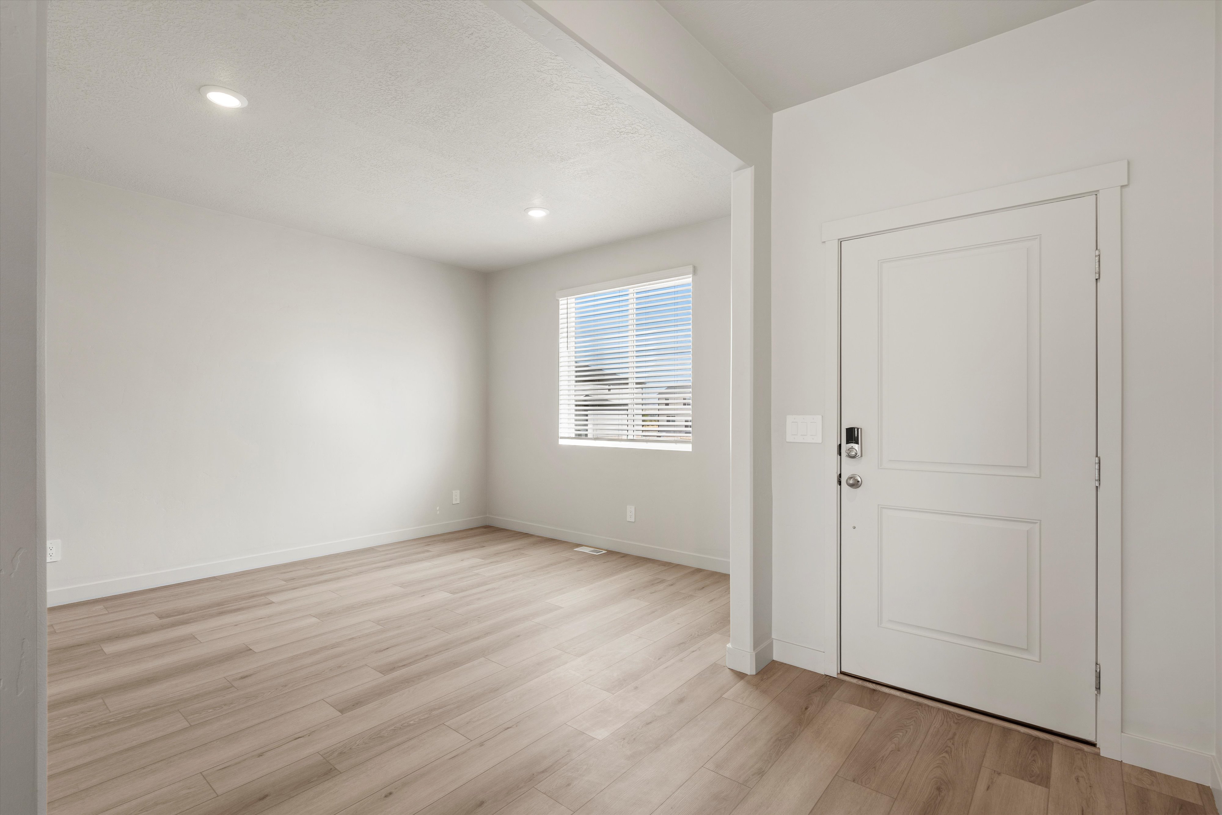 Bright entry space featuring wood-finish flooring, recessed lighting, and a window with horizontal blinds
