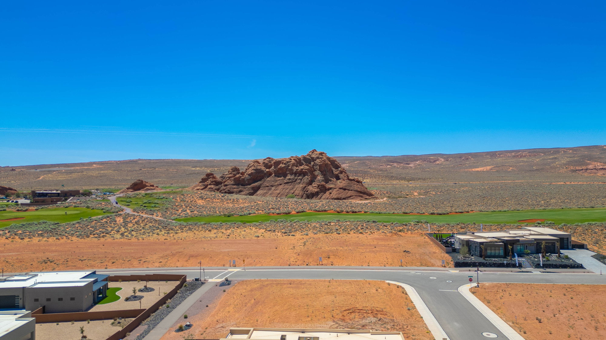 Modern desert community featuring a golf course, distinctive rock formations, and contemporary architecture