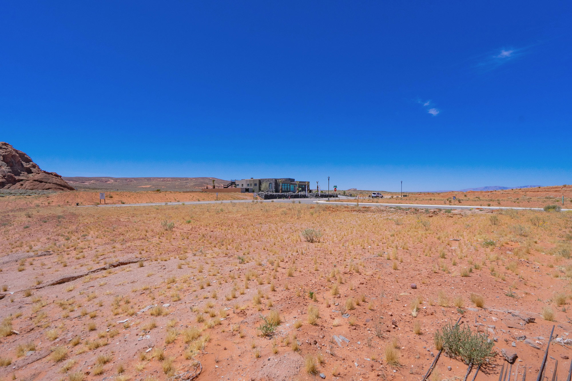 Expansive desert landscape featuring a modern structure with large glass windows and a flat roofline
