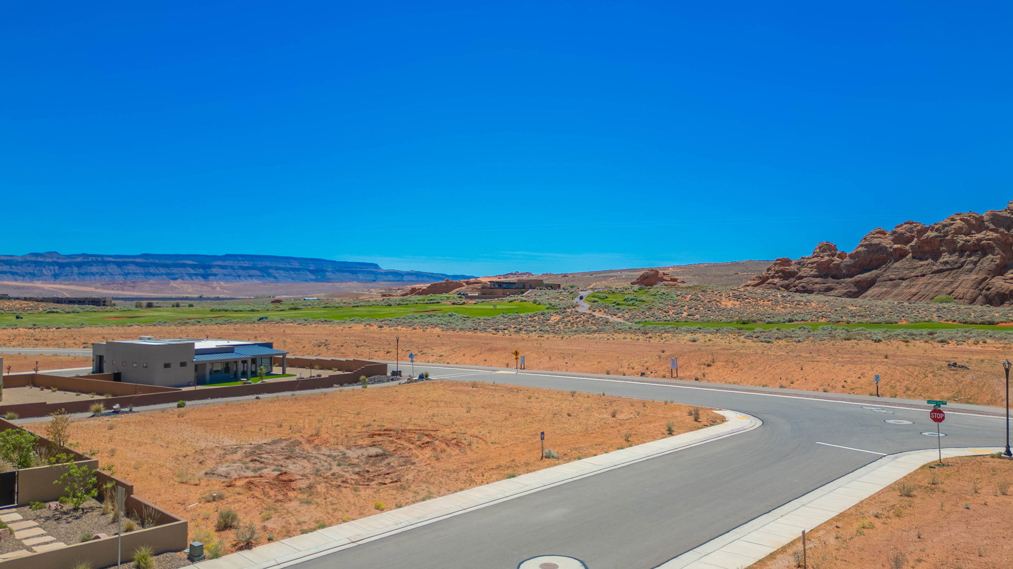 Modern desert landscaping with a flat roofline and integrated covered patio