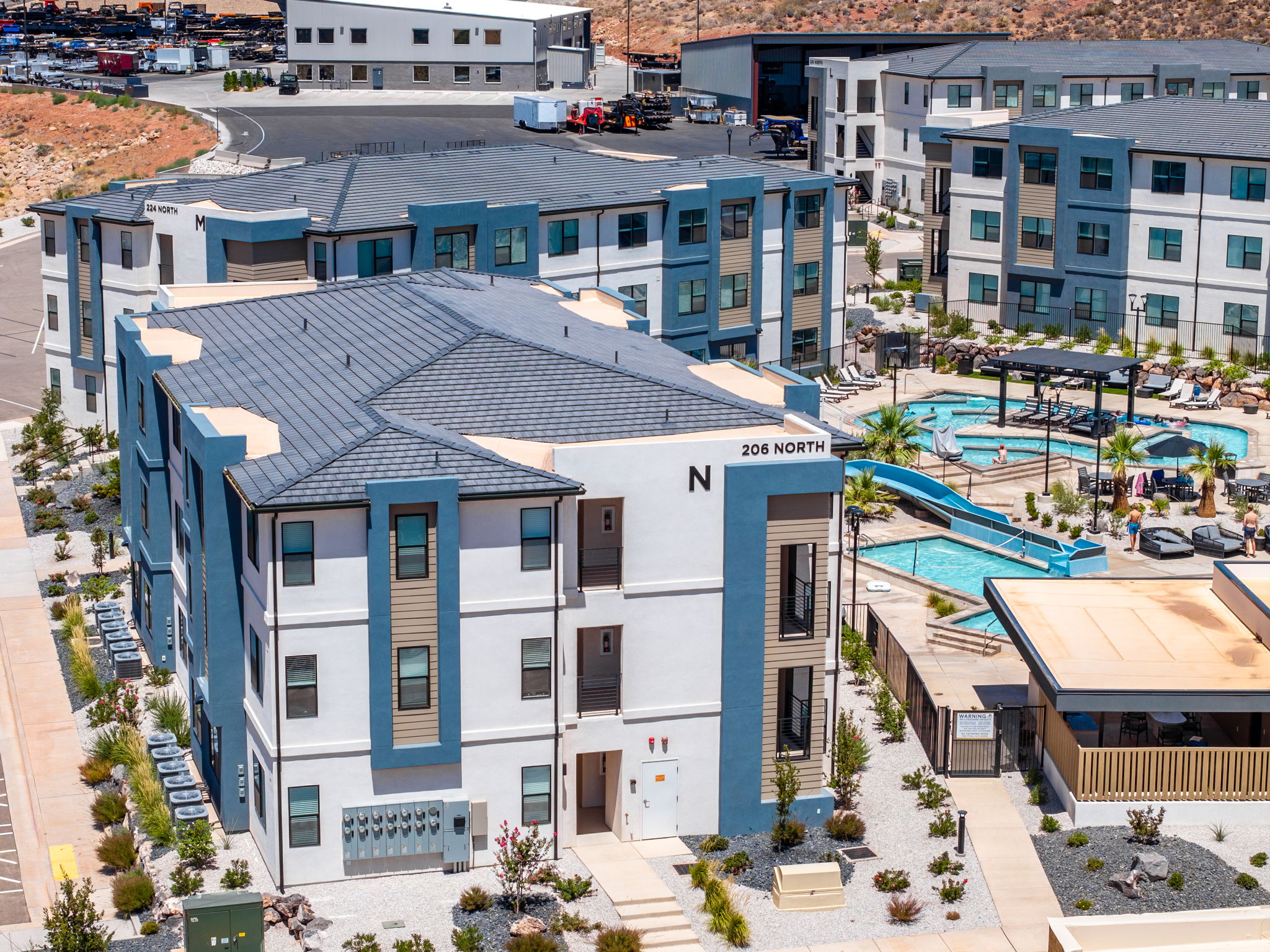 Contemporary multi-story building featuring a white and blue exterior with tan siding accents