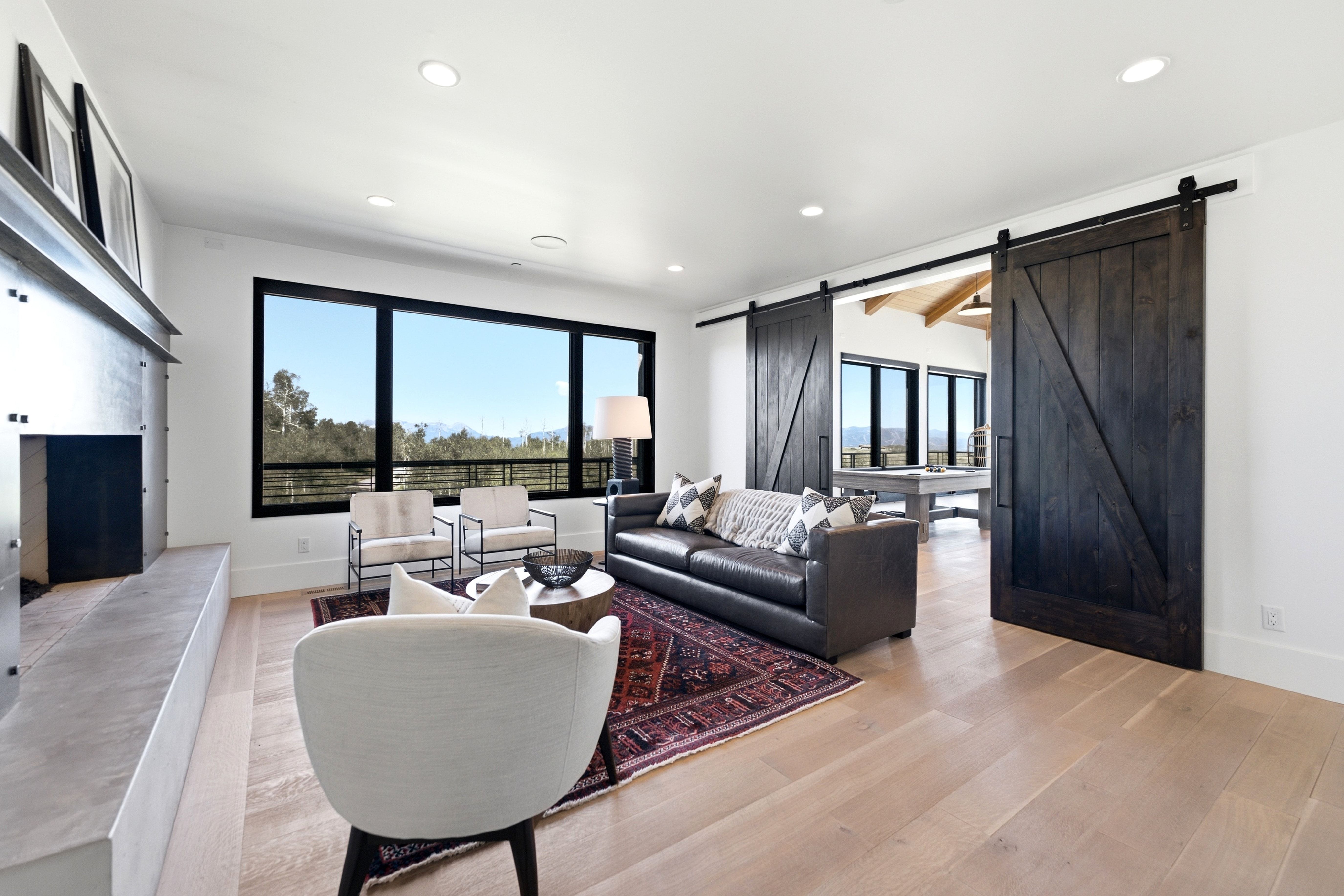 Spacious living area featuring light wood-finish flooring and recessed lighting