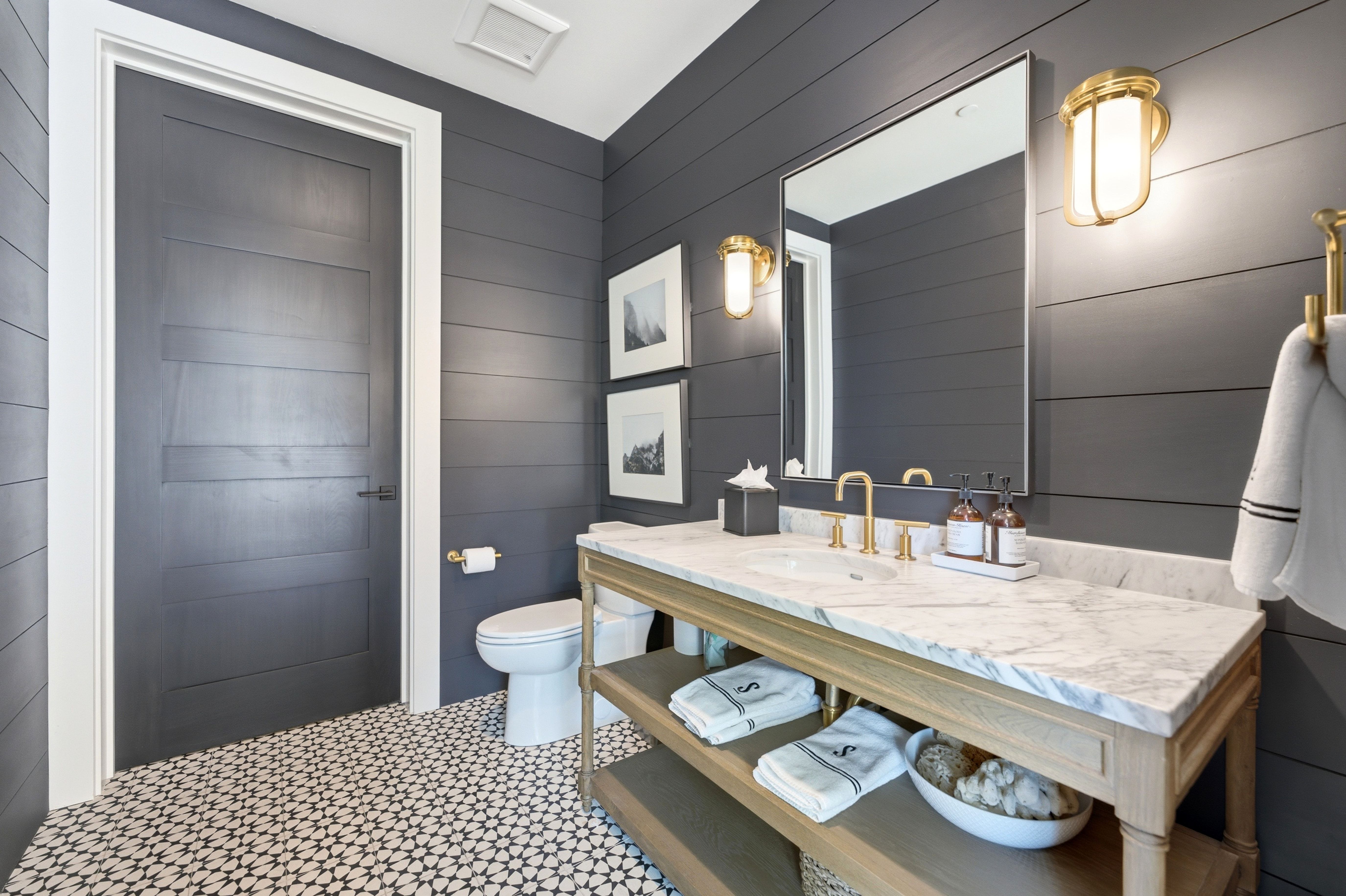 Vanity featuring a marble countertop, undermount sink, and brass-finish fixtures