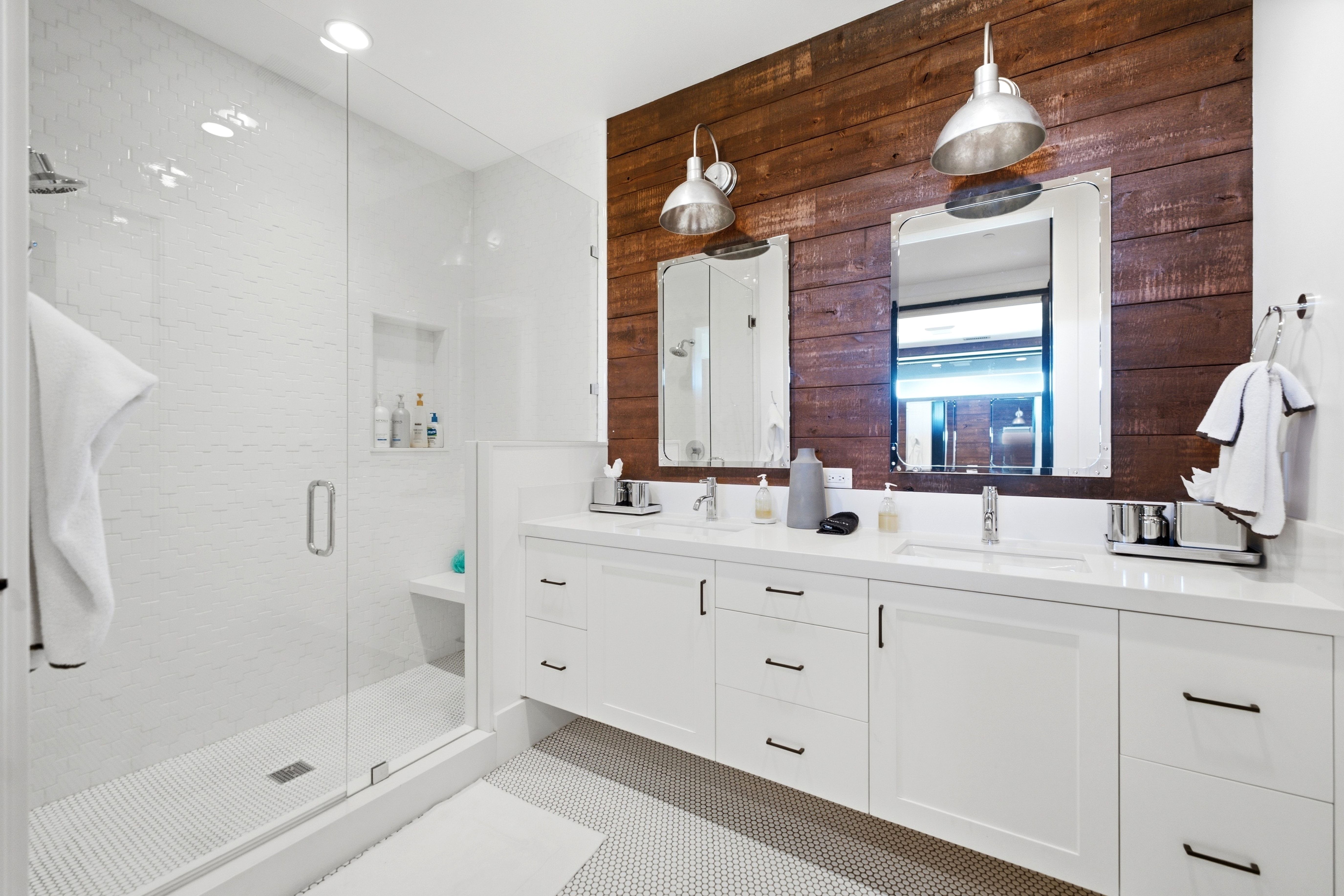 Double vanity with white cabinetry, integrated sinks, and industrial-style pendant lighting