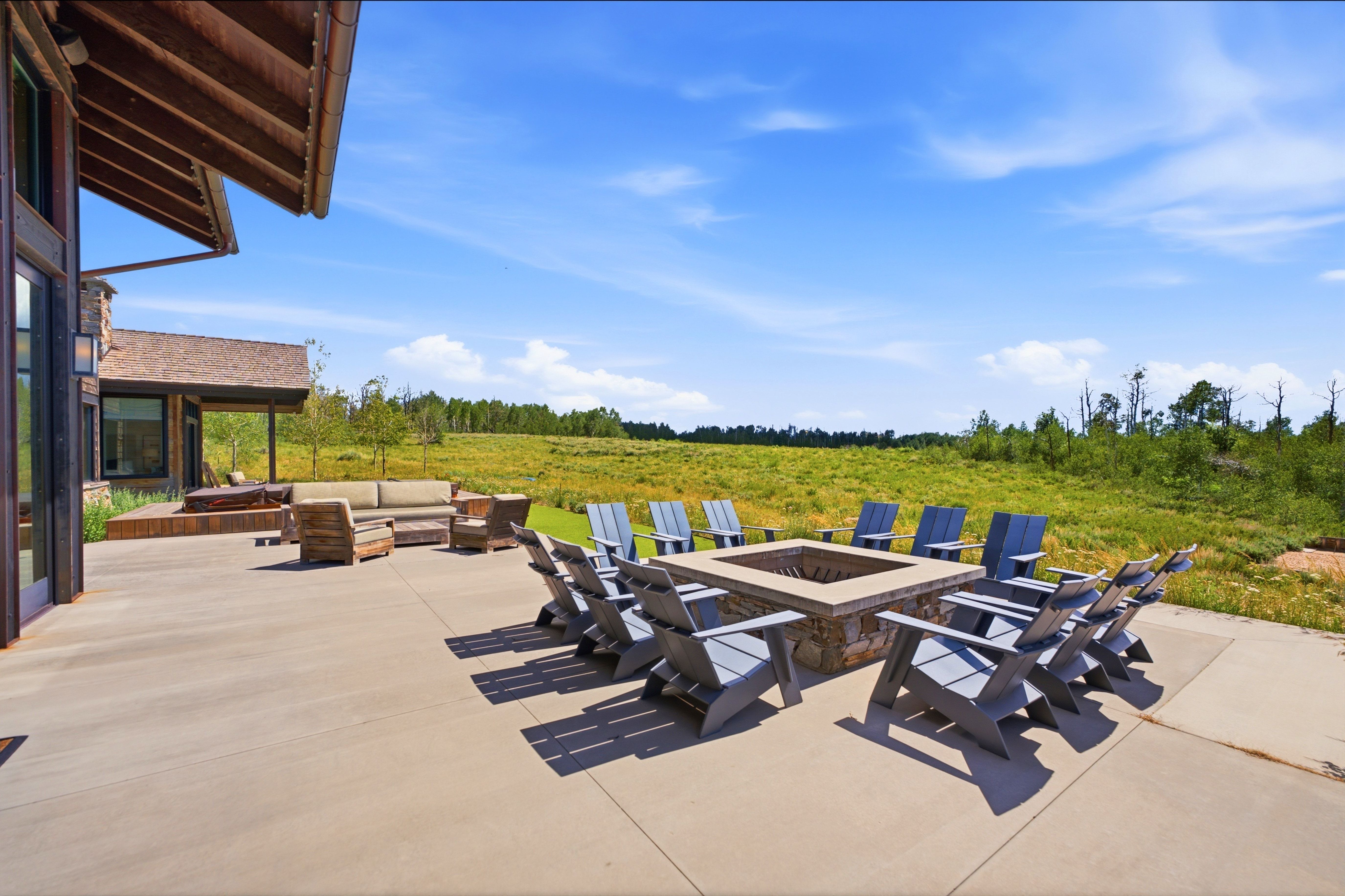 Expansive concrete patio featuring a built-in stone fire pit