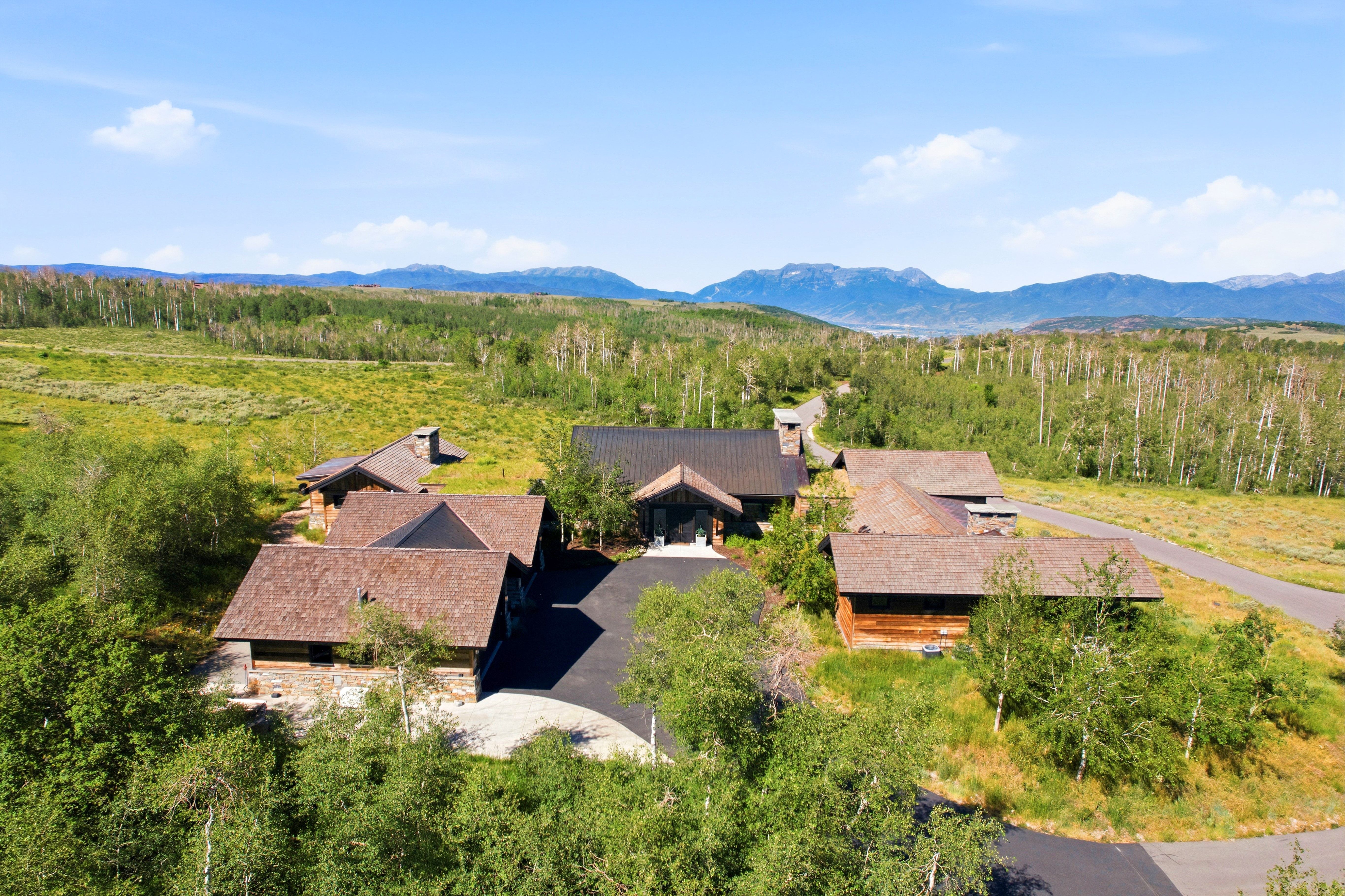 Expansive property featuring multiple structures with dark roofs and wood siding