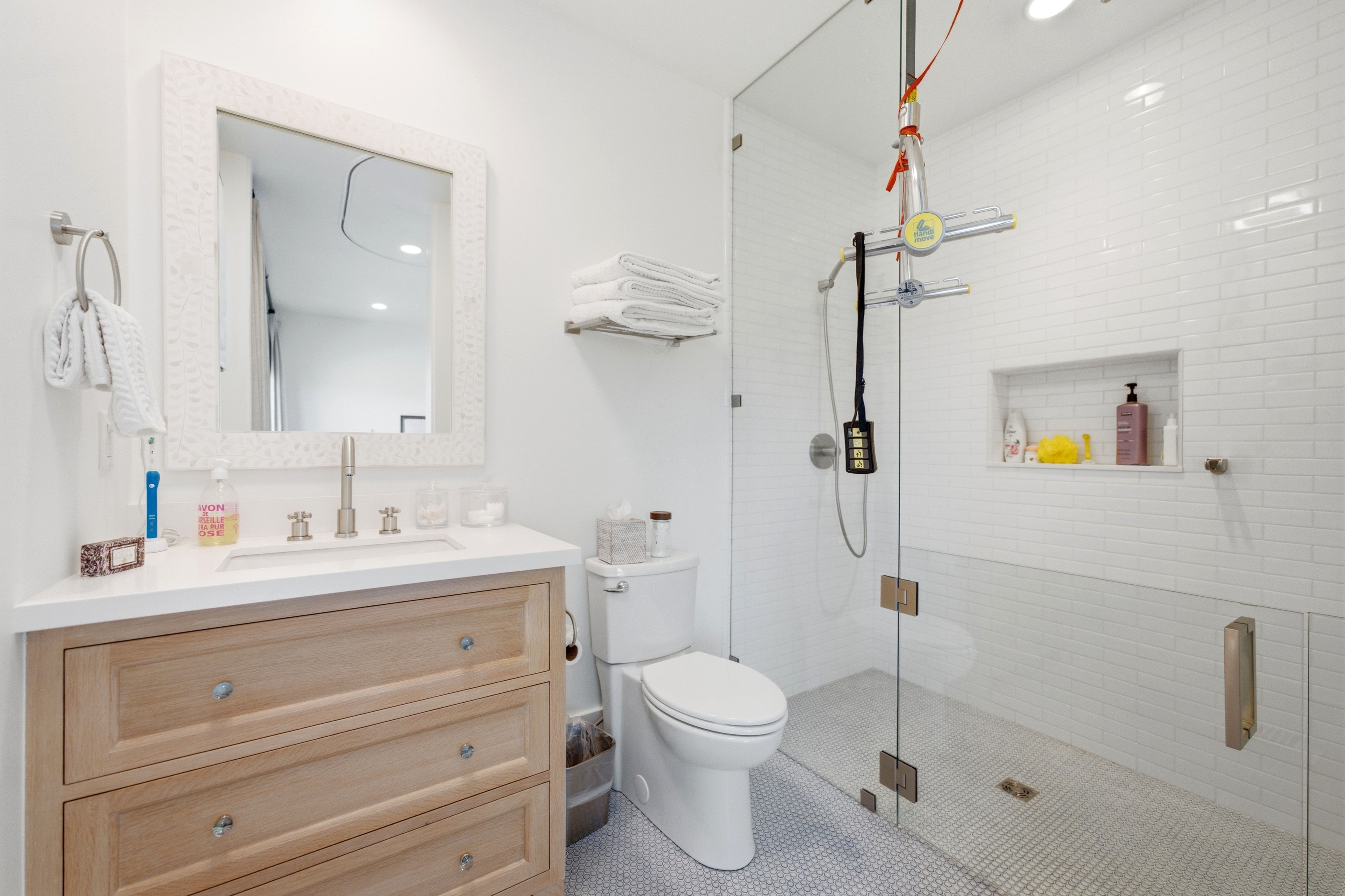Modern bathroom featuring a glass-enclosed shower with subway tile surround and integrated niche