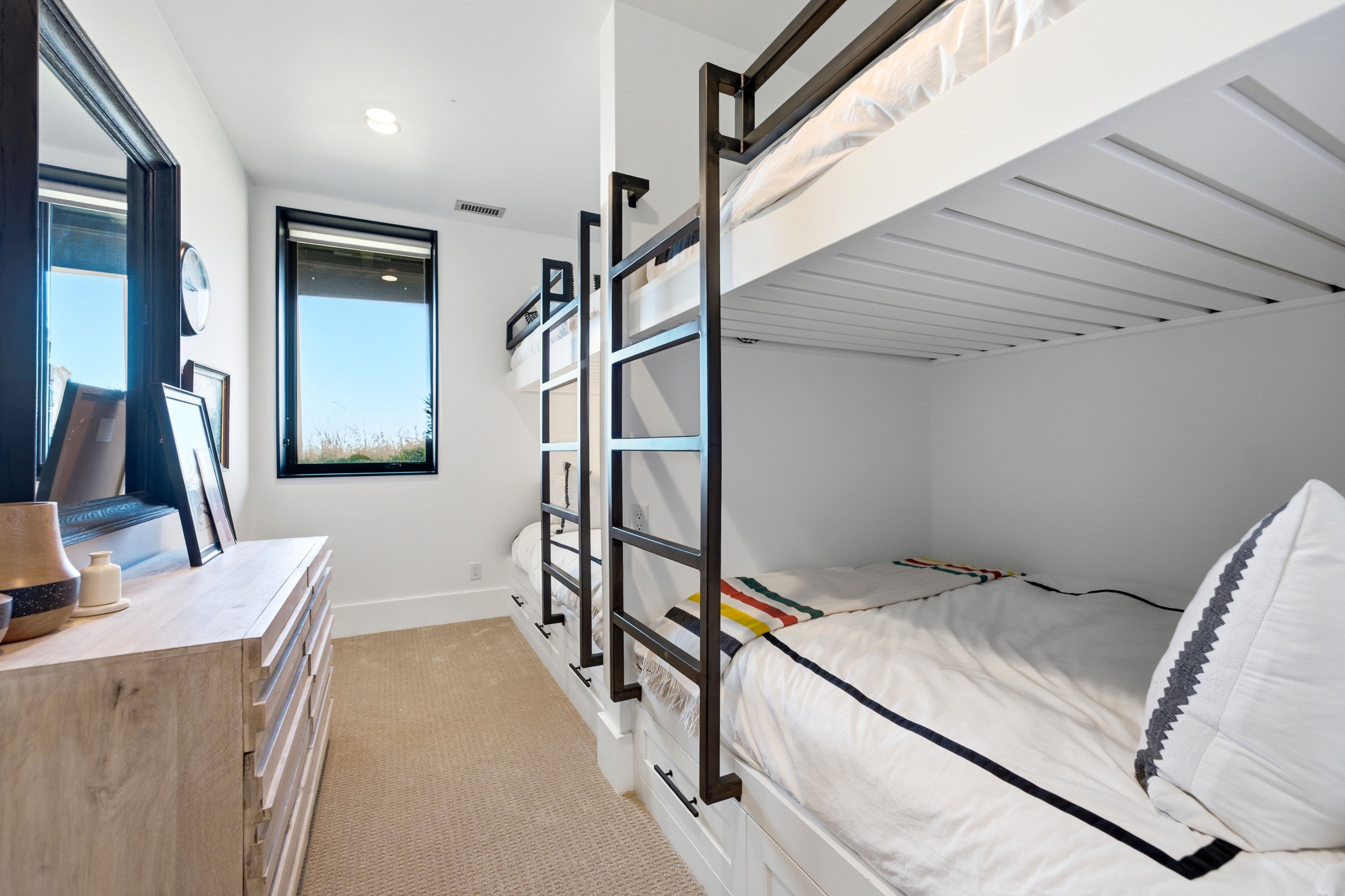 Built-in bunk beds with integrated drawers and metal ladders