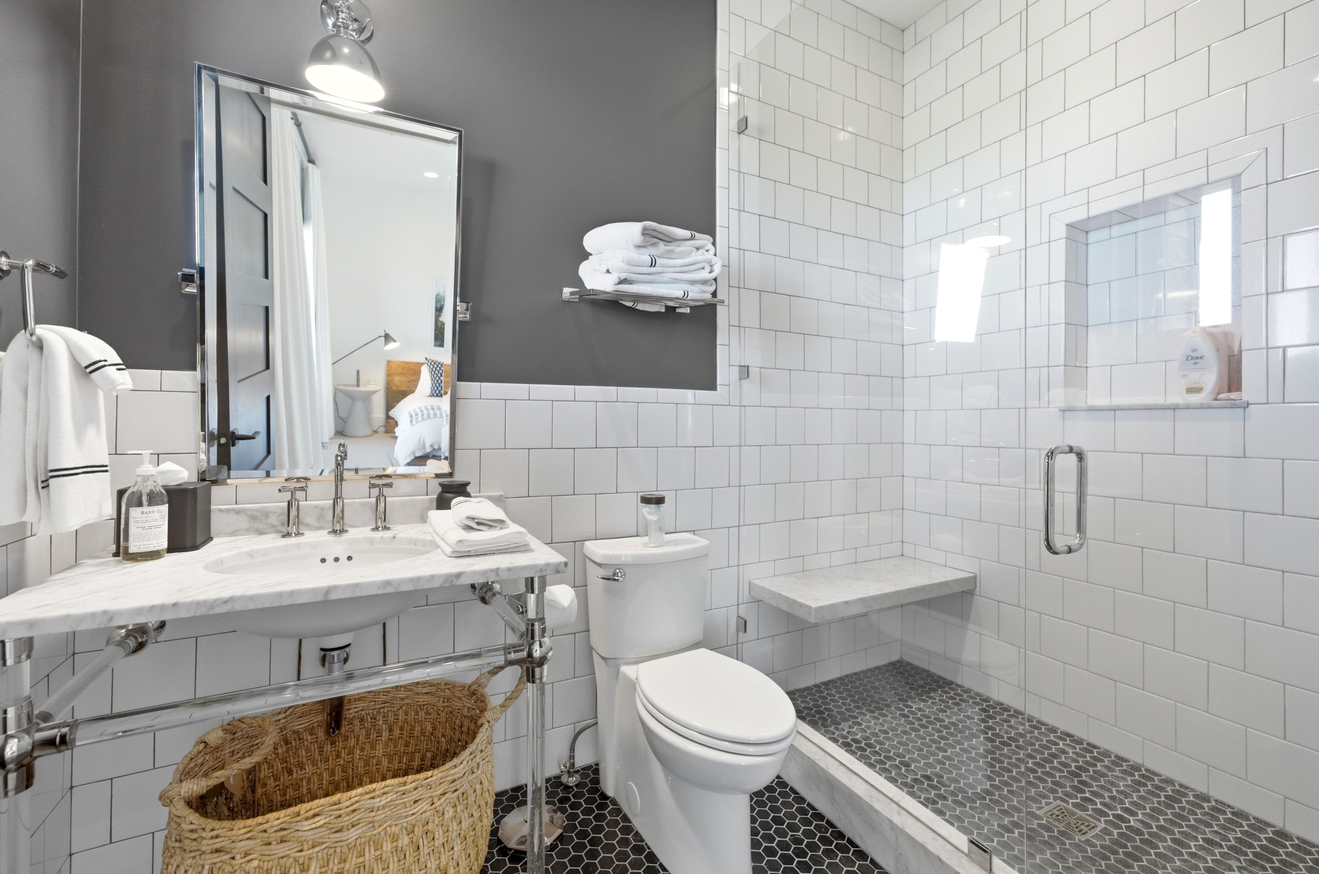 Bathroom featuring a glass-enclosed shower with white subway tile, a built-in shower niche, and a stone bench
