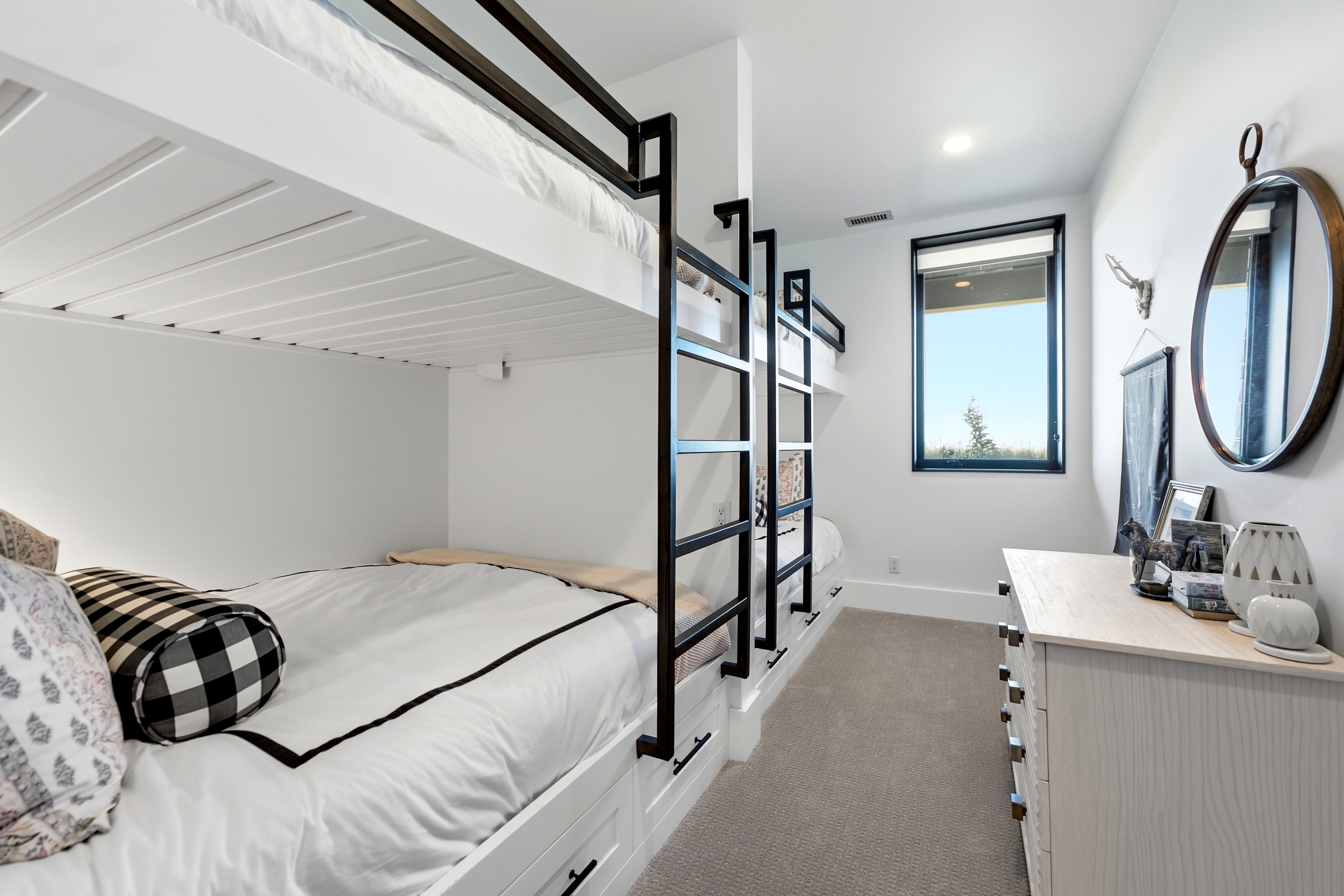 Built-in bunk beds featuring black metal frames and integrated storage drawers