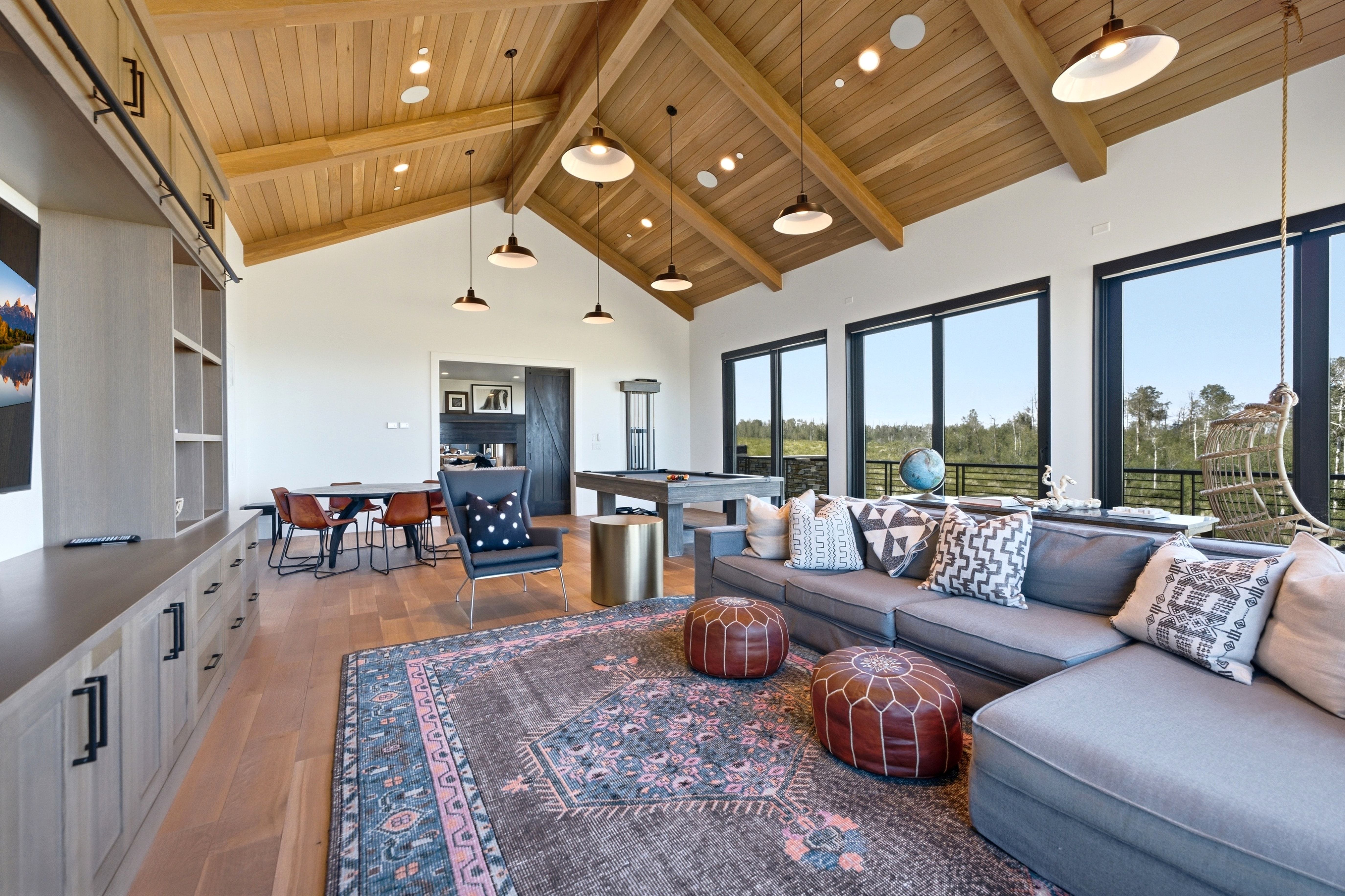 Vaulted wood-finish ceiling with exposed beams and pendant lighting