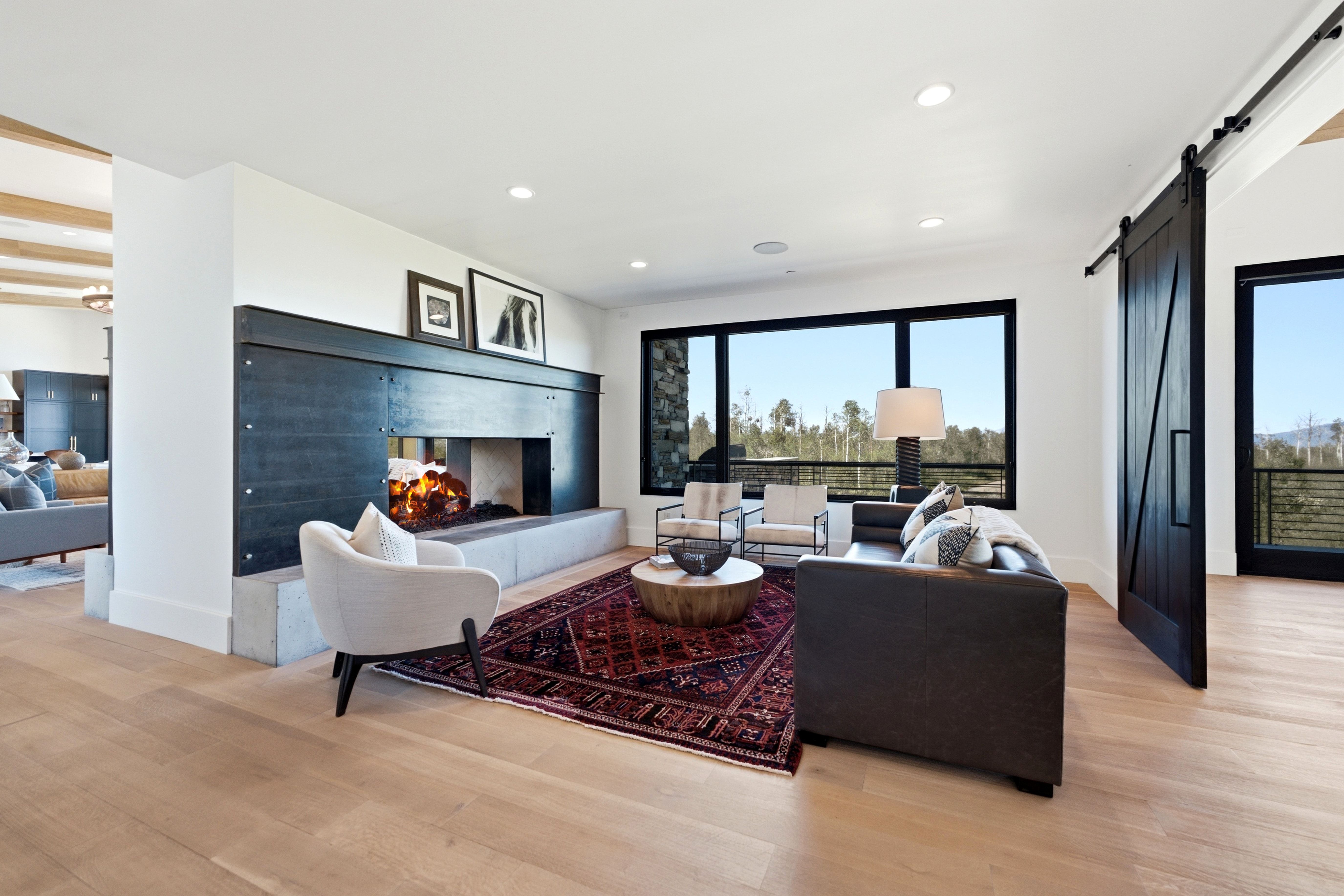 Living area featuring a modern linear fireplace with a stone hearth and dark paneling