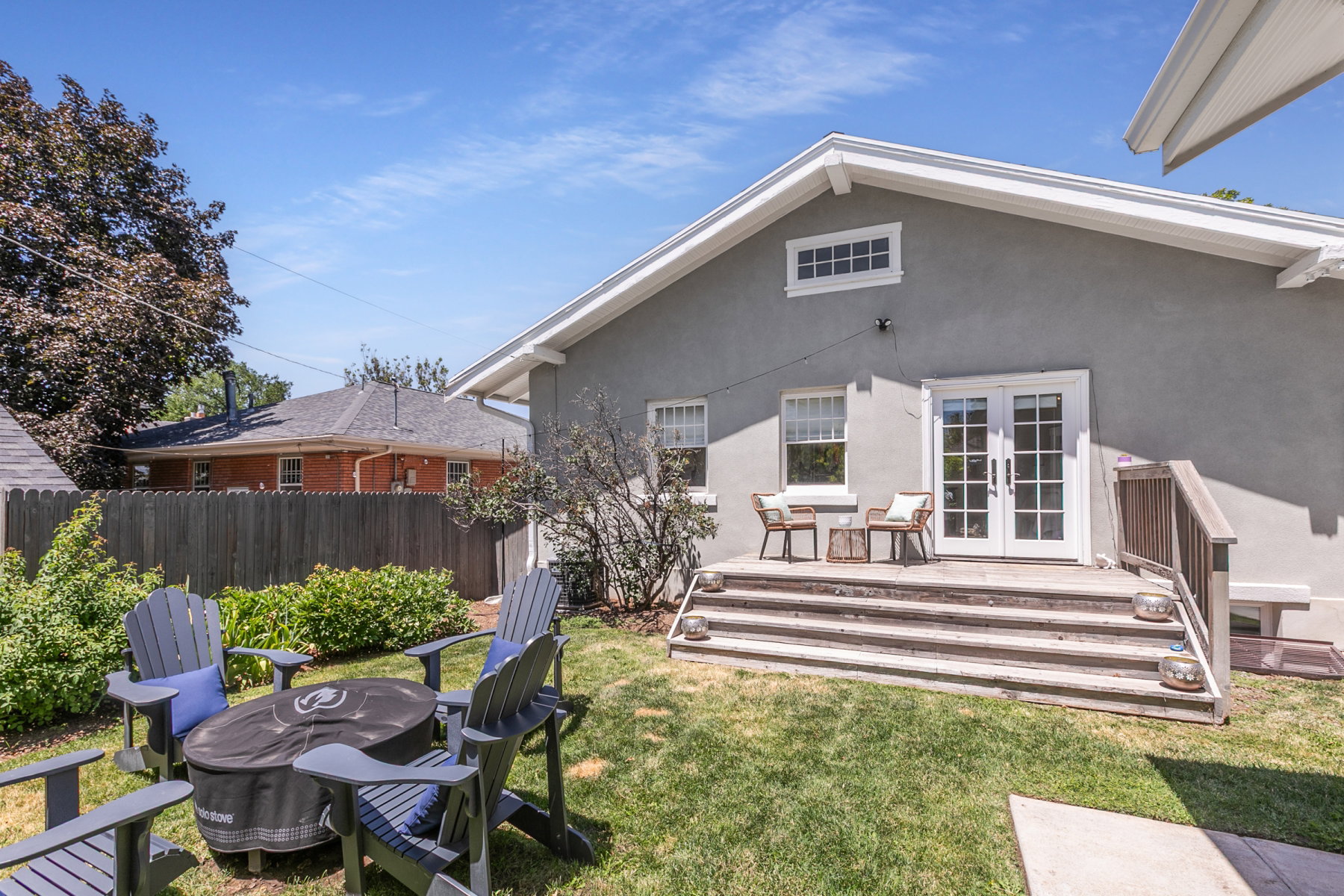 Expansive backyard featuring a manicured lawn, established landscaping, and a privacy fence