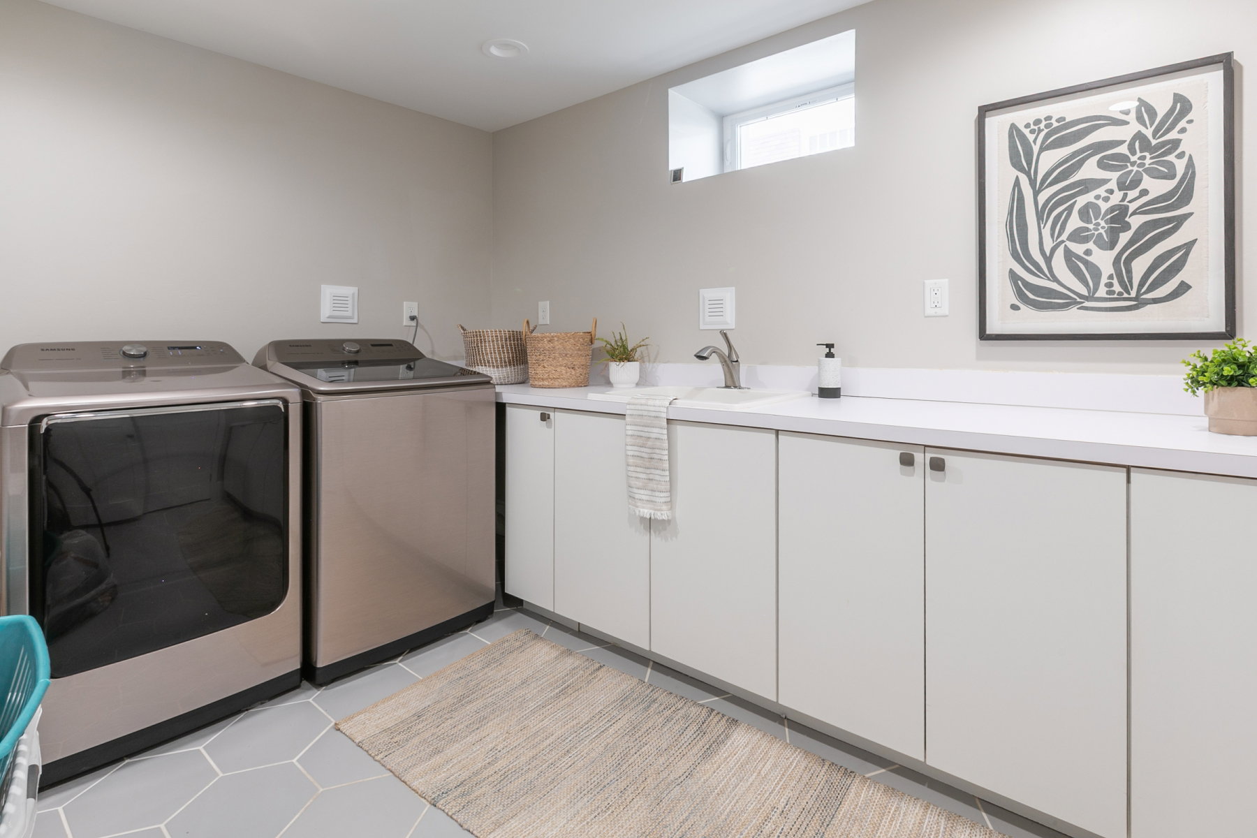 Laundry room with contemporary flat-panel cabinetry, a utility sink, and white countertop