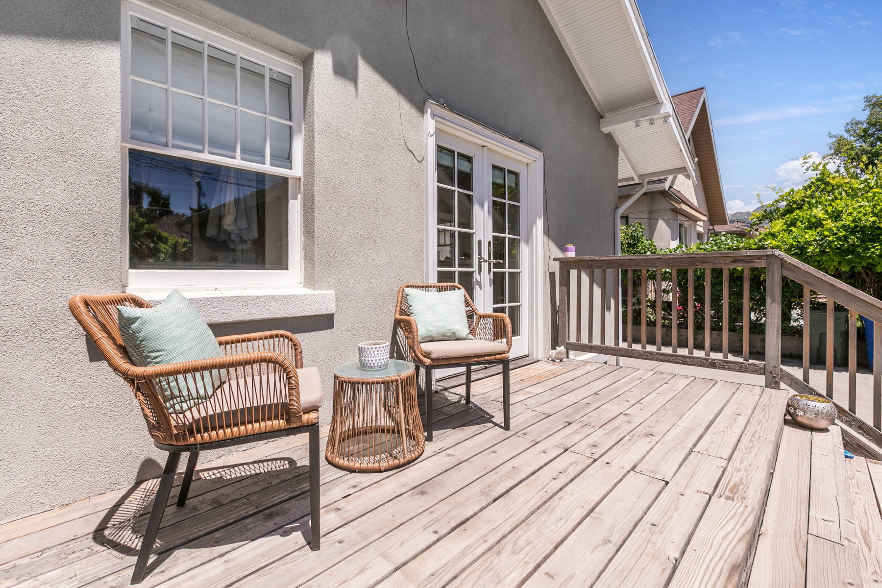 Outdoor deck featuring wood plank flooring, a wood railing, and a set of white French doors